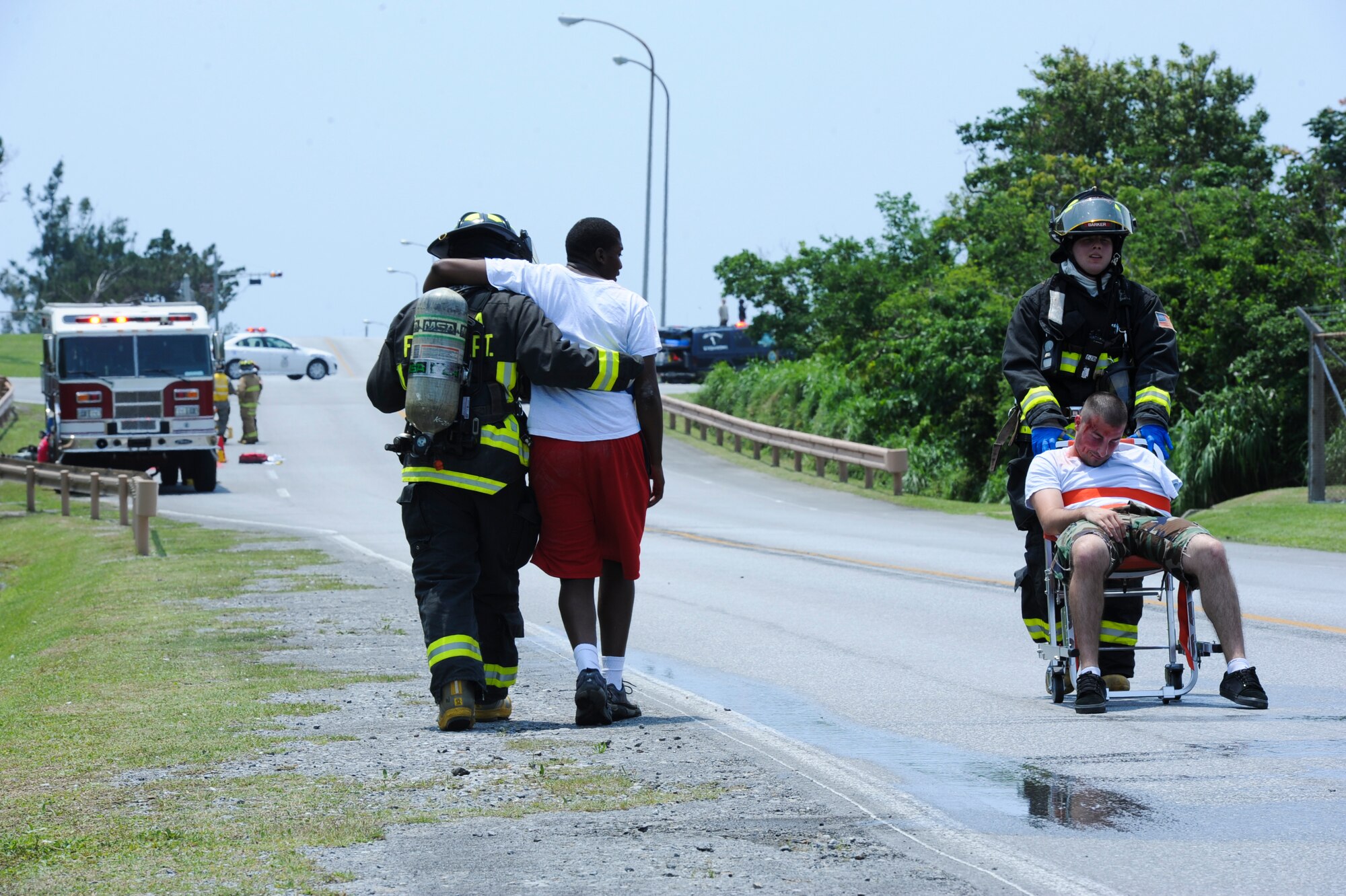 Two Kadena firefighters transport simulated victims to medical care during an emergency management exercise on Kadena Air Base, Japan, April 25, 2013. EMEs are designed to test, train and evaluate the base's ability to respond to crisis situations in the region. (U.S. Air Force photo by Airman 1st Class Justin Veazie/Released)