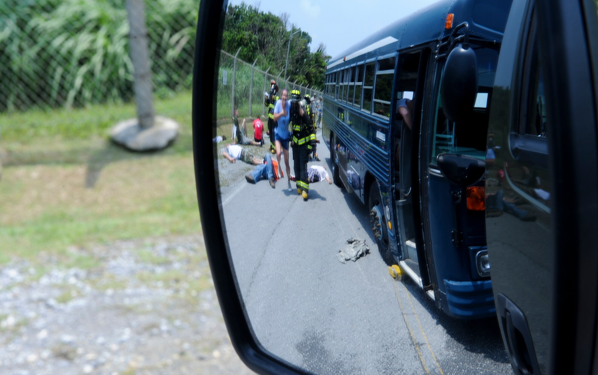 A U.S. Air Force firefighter helps simulated victims to safety during an emergency management exercise on Kadena Air Base, Japan, April 25, 2013. This EME prepared the Airmen for real-world contingency and crisis operations by simulating different scenarios that could happen in their area of response. (U.S. Air Force photo by Airman 1st Class Justin Veazie/Released)