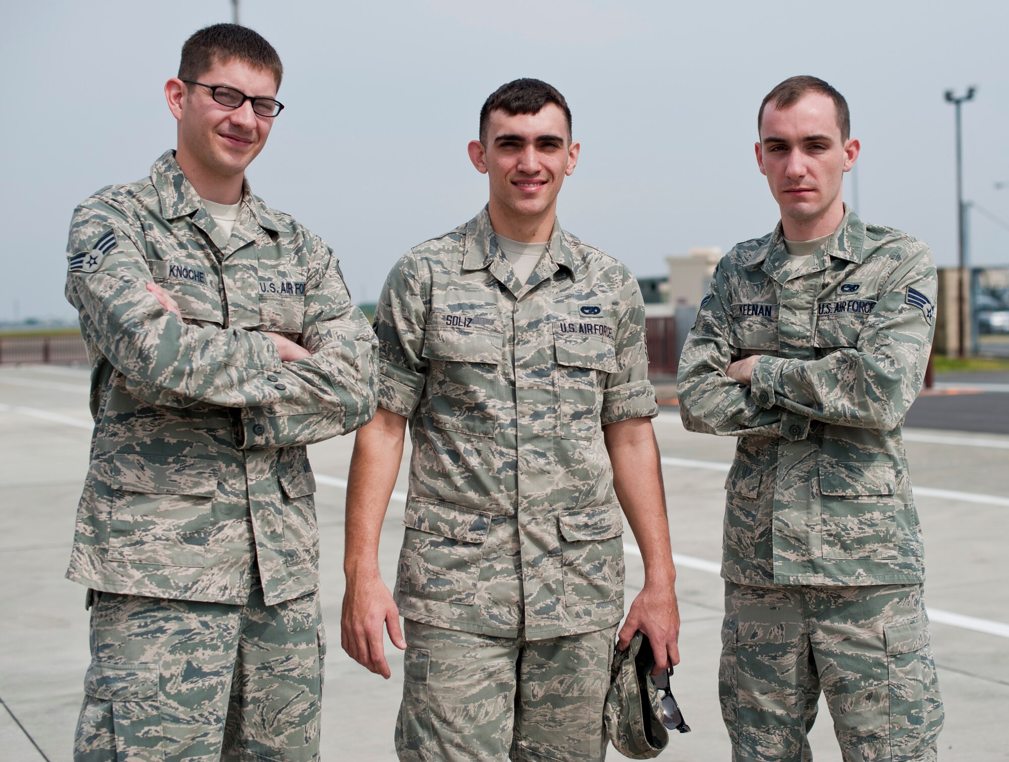 Senior Airman William Knoche, Airman 1st Class Raymond Soliz and Senior Airman Michael Keenan stand together at Yokota Air Base, Japan, April 23, 2013. Soliz attended an event where Knoche and Keenan were coined by the 374th Airlift Wing command chief for saving Soliz who was trapped underneath his car during a maintenance mishap. (U.S. Air Force photo by Airman 1st Class Meagan Schutter/Released)