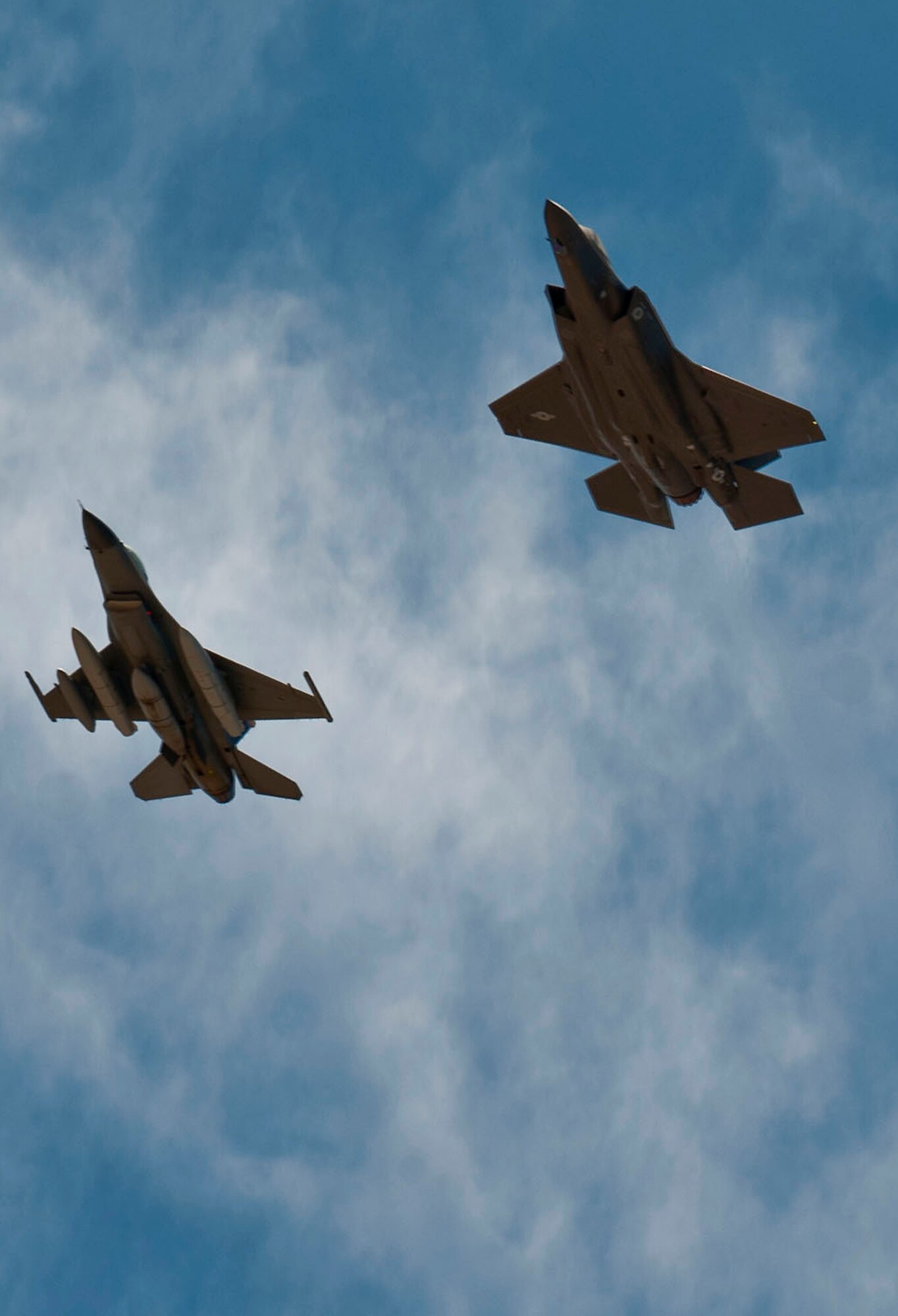 A Lockheed Martin F-35A Lightning II followed by a Lockheed Martin F-16 Fighting Falcon, fly’s over Nellis Air Force Base, Nev., April 24, 2013, prior to landing. The F-35 Lightning II is the fourth of four f-35s to arrive here. (U.S. Air Force photo by Senior Airman Daniel Hughes)