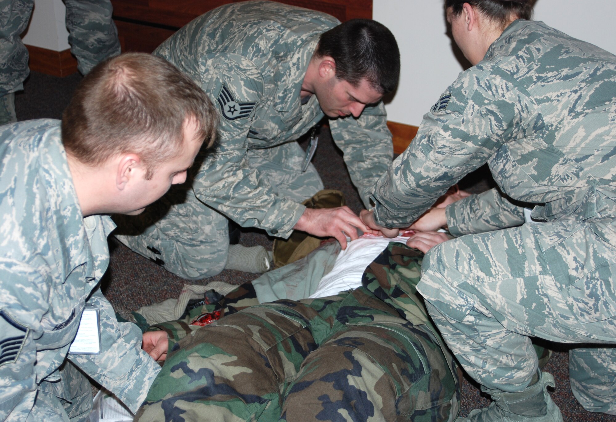 Eielson Air Force Base Airmen provide care to a simulated injured person during an operational readiness exercise April 12, 2013, Eielson Air Force Base, Alaska. Self-aid buddy care instructors placed simulated injury victims throughout the base allowing an opportunity test individual and group response capabilities. (Courtesy photo/Released)