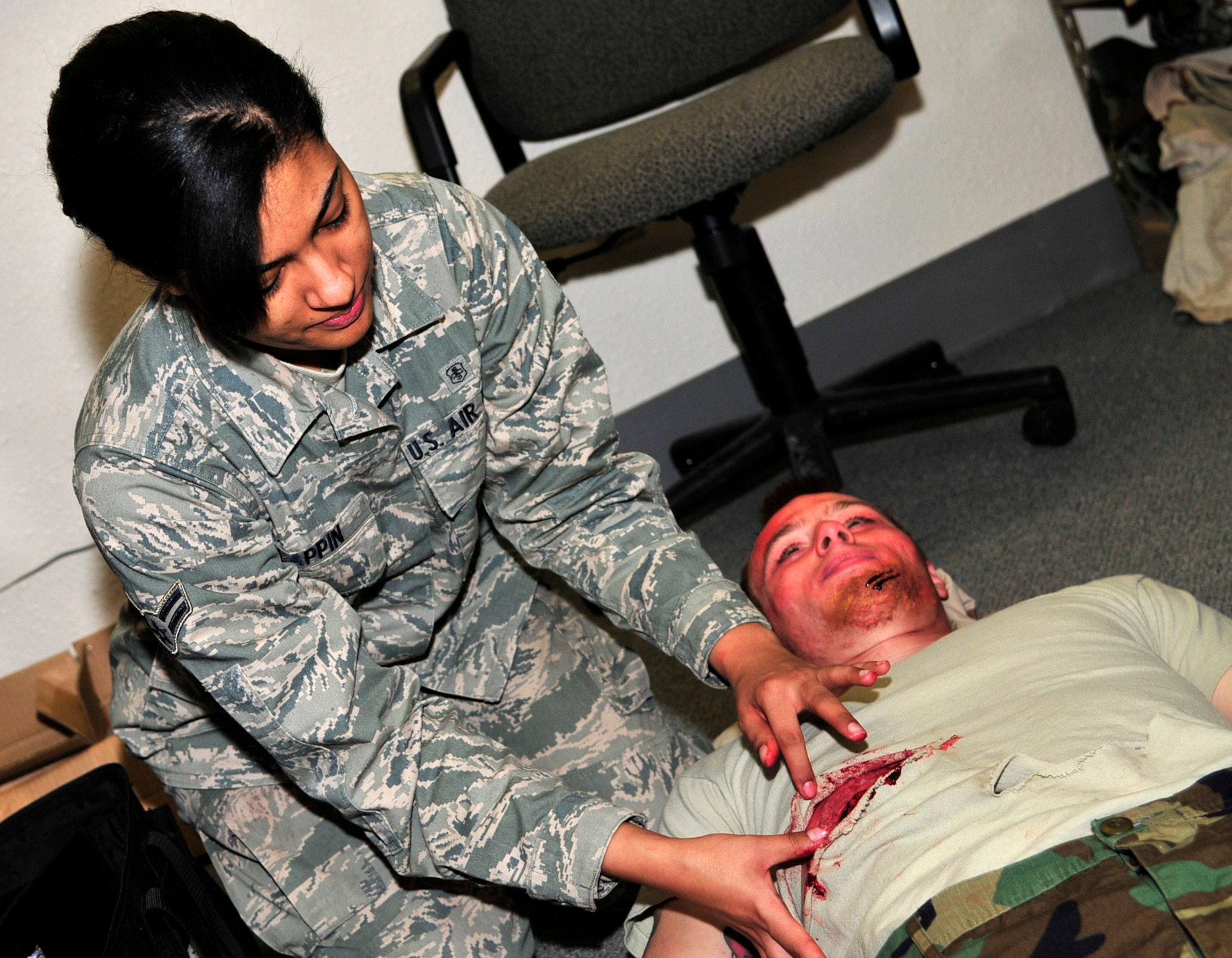 U.S. Air Force Airman 1st Class Kati Lappin, 354th Medical Group dental technician and moulage team member, applies makeup to a simulated injury on Senior Airman Joseph Ellis, 354th Logistics Readiness Squadron vehicle maintainer, during an operational readiness exercise April 11, 2013, Eielson Air Force Base, Alaska. Airman Lappin used liquid latex, fake blood and makeup to make simulated injuries appear real for self-aid buddy care scenarios. (U.S. Air Force photo by Tech. Sgt. Tim Jenkins/Released)