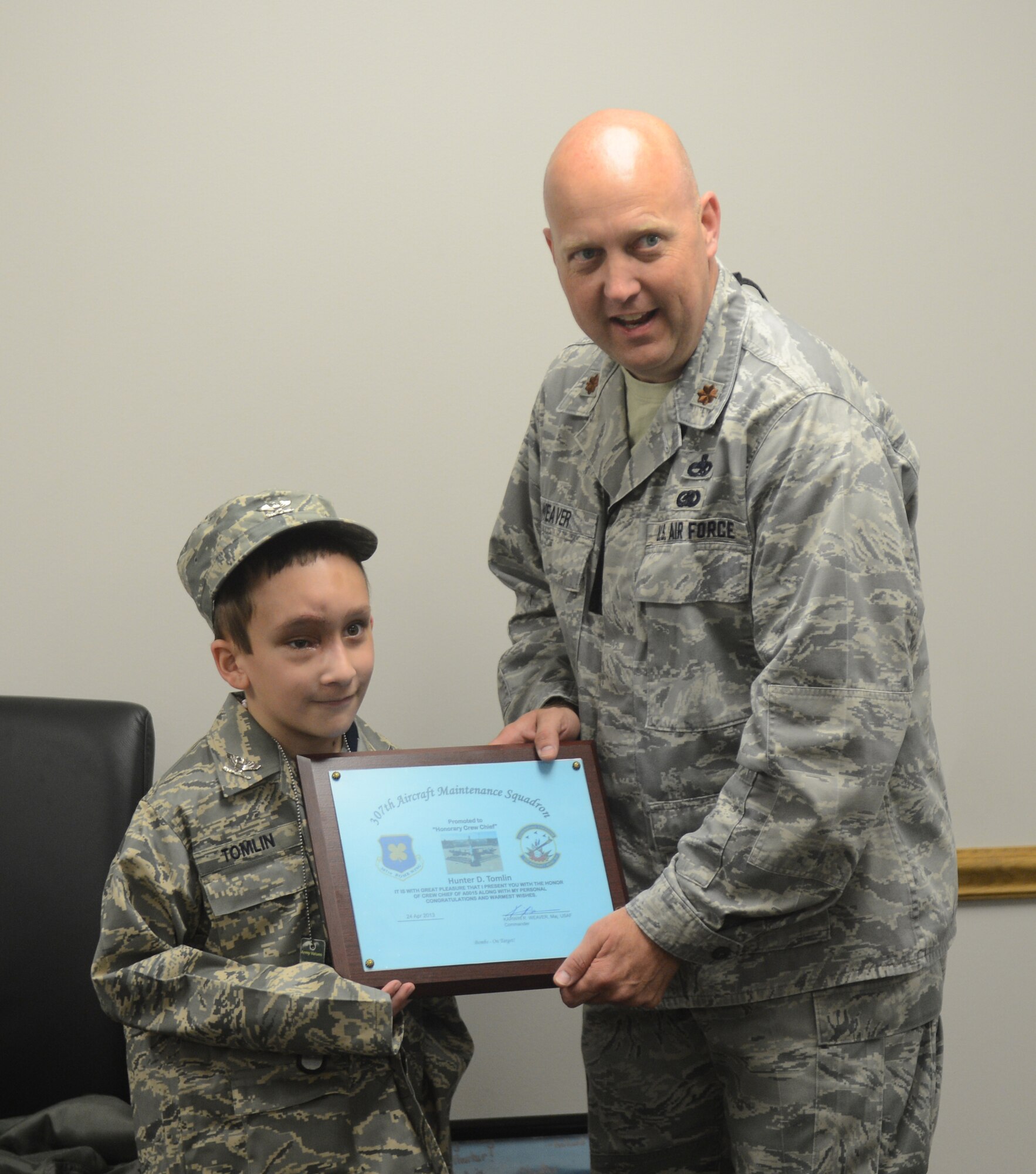 Maj. Karwin Weaver, 307th Aircraft Maintenance Squadron commander, presents Hunter Tomlin, 8, with a plaque designating him as a B-52H Stratofortress honorary crew chief on Barksdale Air Force Base, La, April 24, 2013.Tomlin was diagnosed with neurofibromatosis when he was only 3 months old. (U.S. Air Force photo/Senior Airman Micaiah Anthony)
