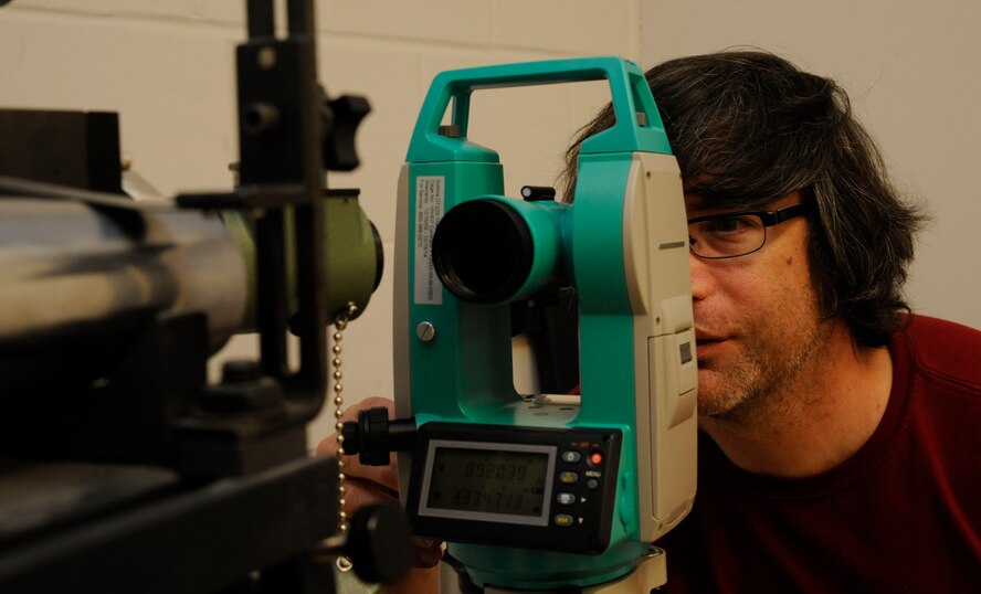 Jeff Gaetz, Precision Measurement Equipment Laboratory technician, uses a theodolite on Barksdale Air Force Base, La., April 24, 2013. A theodolite is used to ensure optics used by aircrew and heads up displays in aircraft are level and to sight the guns on an aircraft to maintain accuracy. (U.S. Air Force photo/Airman 1st Class Andrew Moua)