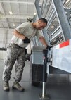 Air Force Reserve Staff Sgt. Anthony Rivera of the 919th Logistics Readiness Squadron sets up a bleacher inside a hangar at Duke Field, Fla.  The project was one of many during preparation for the 919th Special Operations Wing's official retirement ceremony for its MC-130E Combat Talon I aircraft April 25.  (U.S. Air Force photo/Dan Neely)
