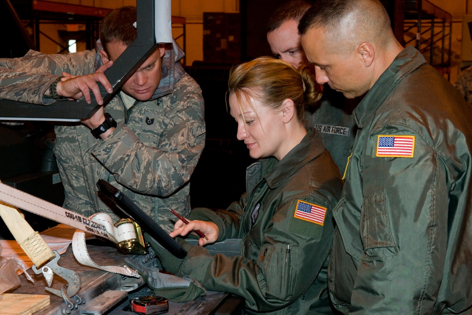GRISSOM AIR RESERVE BASE, Ind. -- Tech. Sgt. Jessie Rood, 434th Operations Support Squadron boom operator, and Staff Sgt. Clayton Duncan, 72nd Air Refueling Squadron boom operator, examine cargo specifications during cargo loading training here April 13. The purpose of the training was to keep 49th Aerial Port Flight Airmen proficient at transporting and loading cargo onto KC-135R Stratotankers and also allow aircrew an opportunity to see how the aerial port prepares the cargo beforehand. (U.S. Air Force photo/Senior Airman Andrew McLaughlin) 