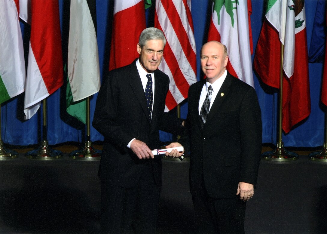From left, FBI Director Robert Mueller presents Rick Trull, AEDC’s emergency services manager, a certificate for completing the FBI National Academy Program course in March. (Photo provided)