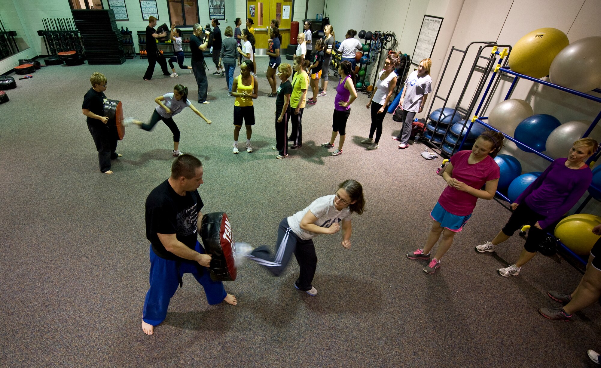 Participants in a self-defense class kick a combat sports bag April 18, 2013, at Dyess Air Force Base, Texas. The two-hour class included tips on how to avoid becoming a victim and lessons on how to temporarily subdue an aggressor if attacked. (U.S. Air Force photo by Airman 1st Class Jonathan Stefanko/ Released)