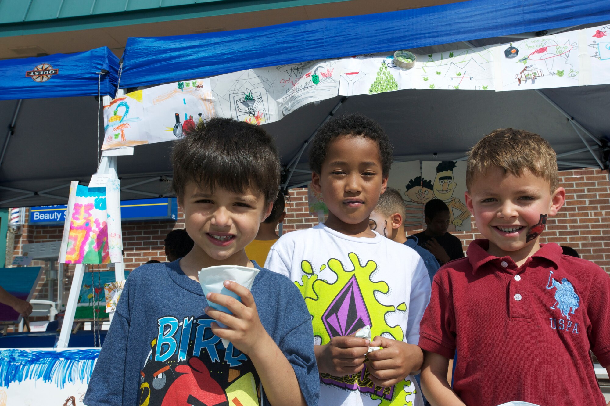 (Right) Daniel Beiman, son of Silvia and Zev Beiman  , Ichiwa Davidson, son of Emi Davidson , and Everett Goyert, son of Petty Officer 1st Class Devon Goyert, pose in front of a collection of drawings that tells a story at the Children’s Art Gala April 17, 2013, at Joint Base Charleston – Weapons Station, S.C. The boys spent many hours, working together, in order to complete the project. (U.S. Air Force photo / Airman 1st Class Tom Brading)