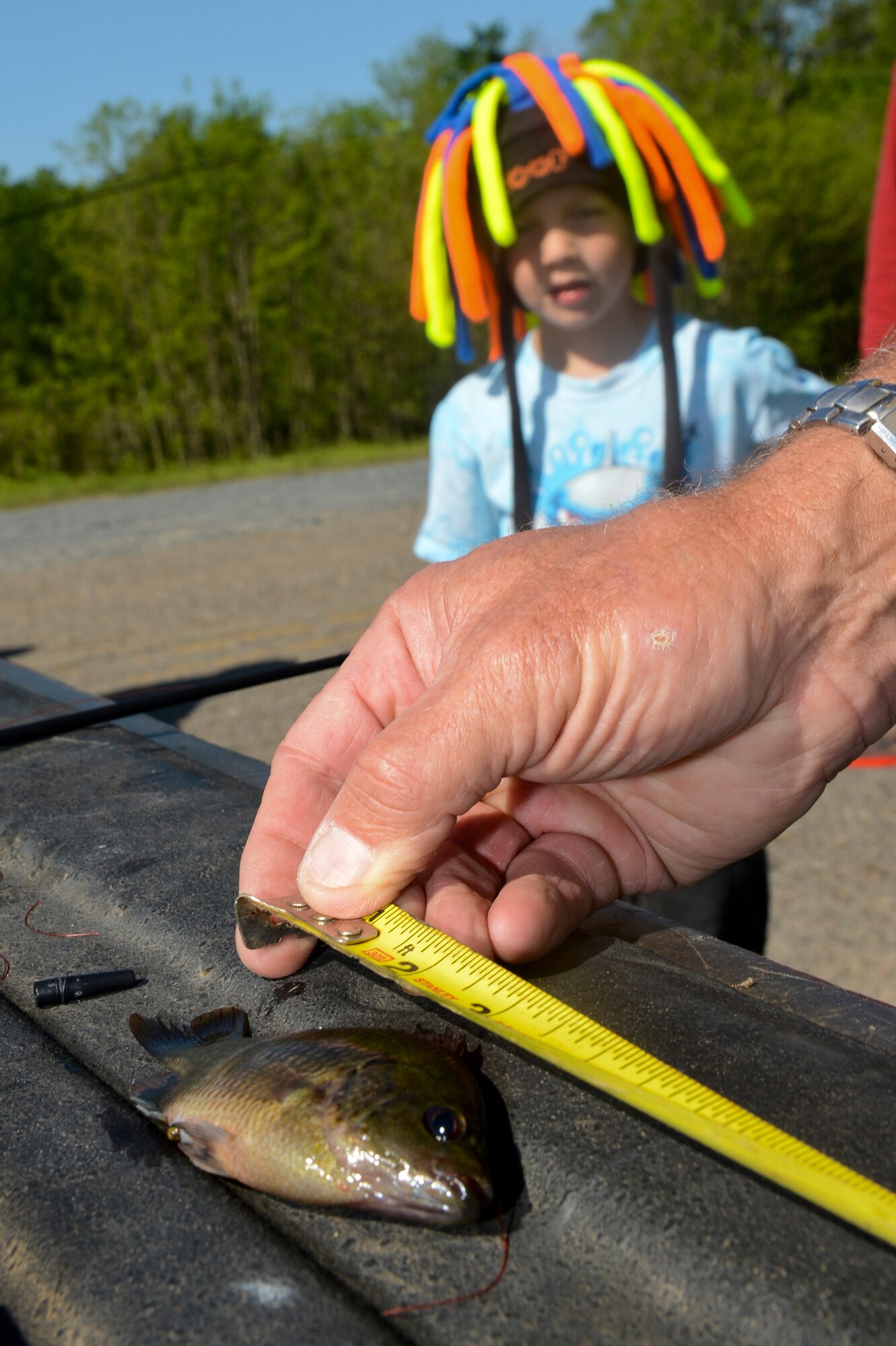 A child watches as fish is measured during the 8th annual Kids Fish event on Barksdale Air Force Base, La., April 20, 2013. Prizes were awarded to the children who caught the most, largest and smallest fish, along with the child with the coolest hat. The largest fish caught during the event was 15 inches long. (U.S. Air Force photo/Senior Airman Micaiah Anthony)
