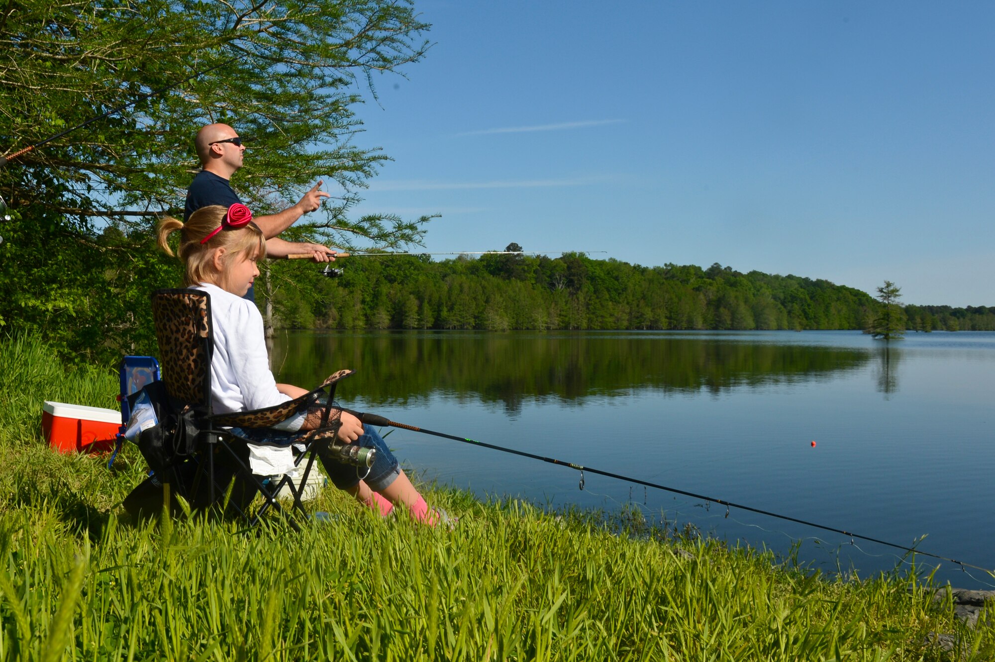 Capt. Michael Plourde, 96th Bomb Squadron, cast a line with his daughter during the 8th annual Kids Fish event on Barksdale Air Force Base, La., April 20, 2013. The event was held to increase recreational outings for military families with base access. The 120 children that participated in the event received a fishing starter kit along with other goodies. (U.S. Air Force photo/Senior Airman Micaiah Anthony)
