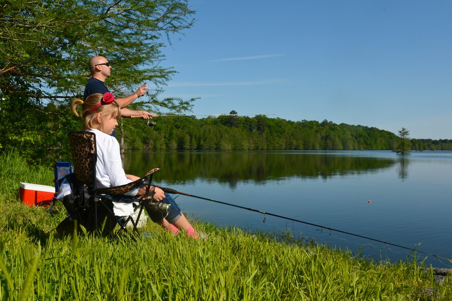 Capt. Michael Plourde, 96th Bomb Squadron, cast a line with his daughter during the 8th annual Kids Fish event on Barksdale Air Force Base, La., April 20, 2013. The event was held to increase recreational outings for military families with base access. The 120 children that participated in the event received a fishing starter kit along with other goodies. (U.S. Air Force photo/Senior Airman Micaiah Anthony)