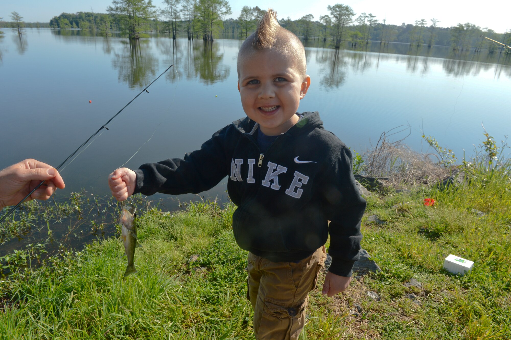 The son of Capt. Michael Plourde, 96th Bomb Squadron, holds a fish during the 8th annual Kids Fish event on Barksdale Air Force Base, La., April 20, 2013. Plourde's son caught his first fish during the event. (U.S. Air Force photo/Senior Airman Micaiah Anthony) 
