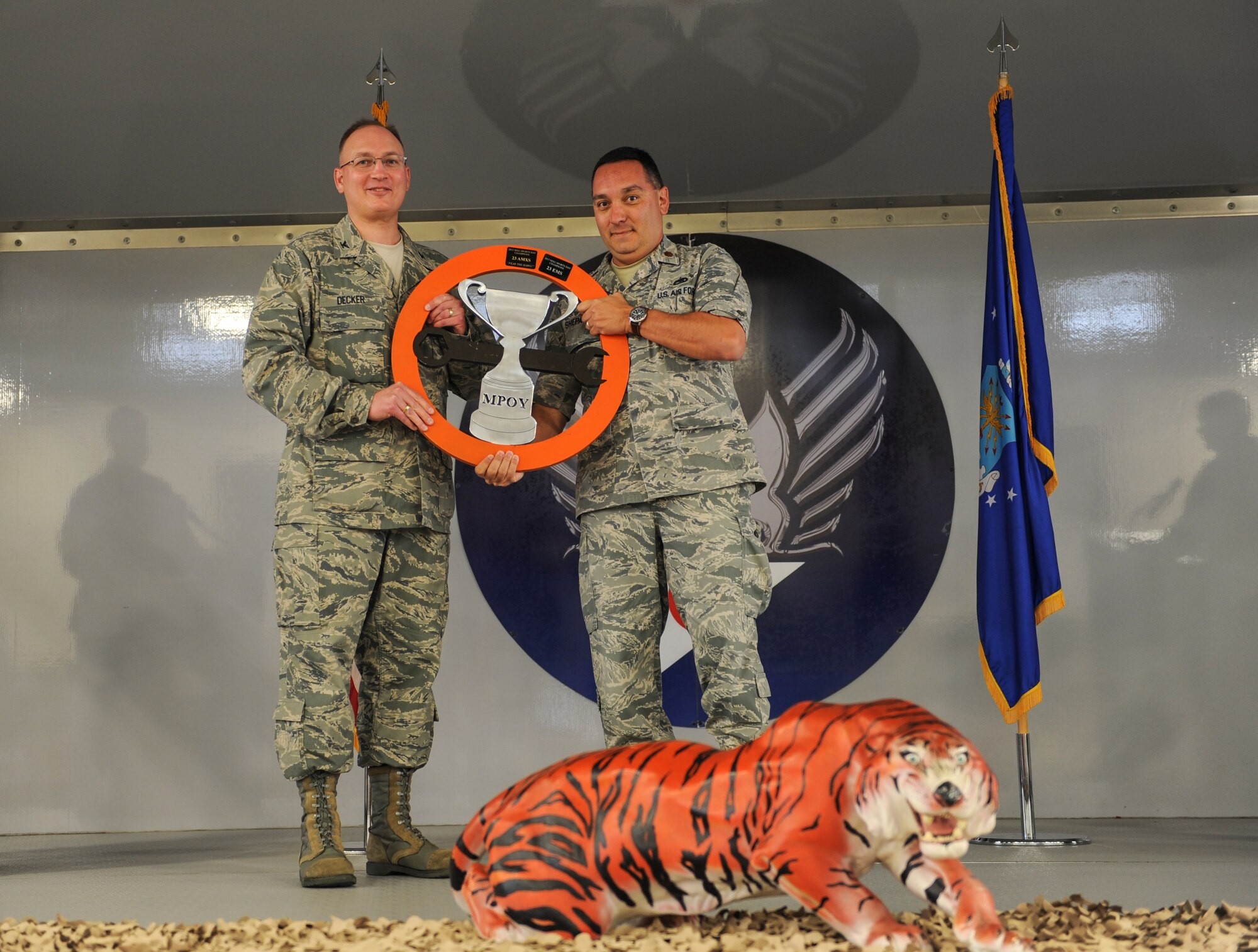 U.S. Air Force Col. Jeffery Decker, 23d Maintenance Group commander (left), hands Maj. Steven Shepan, 23d Equipment Maintenance Squadron commander, the 23d MXG sports day trophy during the 2013 Maintenance Professional of the Year banquet at Moody Air Force Base, Ga., April 19, 2013. The 23d EMS was the winner of this year’s sports day. (U.S. Air Force photo by Airman Alexis Grotz/ Released) 