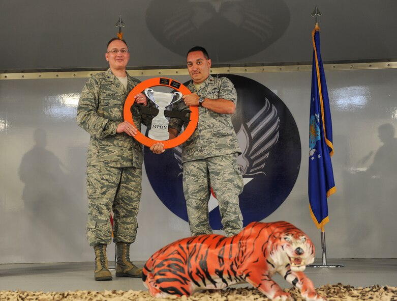 U.S. Air Force Col. Jeffery Decker, 23d Maintenance Group commander (left), hands Maj. Steven Shepan, 23d Equipment Maintenance Squadron commander, the 23d MXG sports day trophy during the 2013 Maintenance Professional of the Year banquet at Moody Air Force Base, Ga., April 19, 2013. The 23d EMS was the winner of this year’s sports day. (U.S. Air Force photo by Airman Alexis Grotz/ Released) 