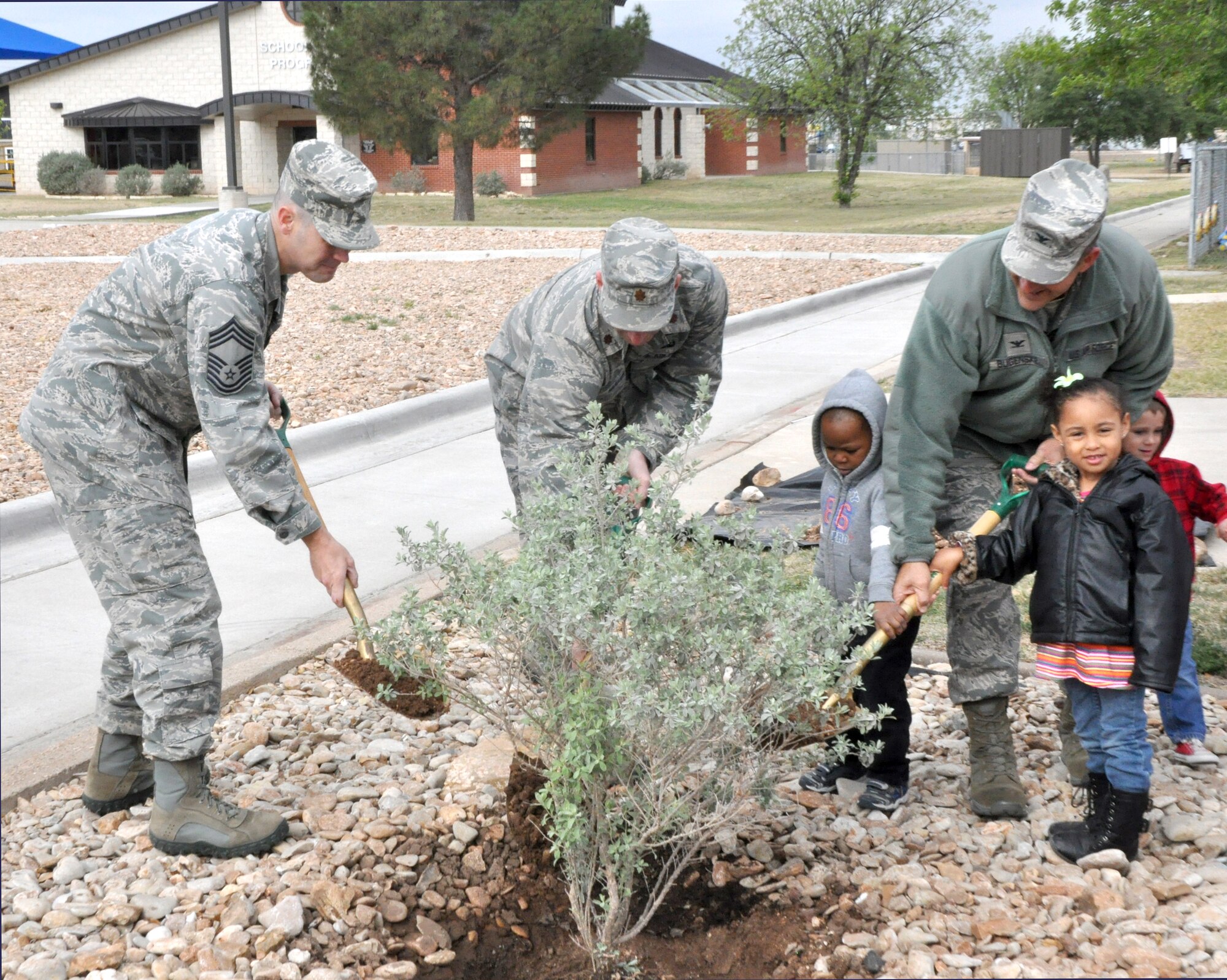 GOODFELLOW AIR FORCE BASE, Texas-- (from right to left) Col. Paul Bugenske, 17th Mission Support Group Commander; Maj. Kurt Muller, 17th Civil Engineer Squadron Commander; and Chief Master Sgt. Matthew Johnson, 17th MSG superintendent, plant a bush at the Children’s Development Center, April 24, in celebration of Earth Day, which was April 22.  Youths from the CDC came to watch and help plant the bush. (U.S. Air Force photo/Airman Jessica Keith)  