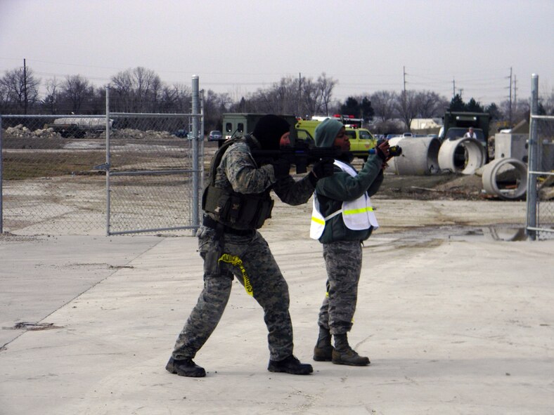 Sniper 1 covers an exit while 2nd Lt. Sheri Lamb of Air Force Research Laboratory, uses a Forward Looking Infrared (FLIR) camera to push imagery to the sensor grid at the request of the incident commander. 

