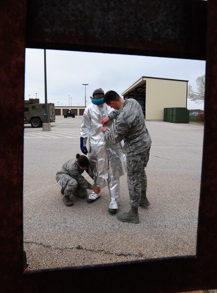 Airmen 1st Class Stephanie Burjass and Joseph Dolan, 509th Security Forces Squadron response force members, help Airman 1st Class Isaac Fox, 509th Security Forces Squadron response force member, don protective equipment before he performs a breeching exercise at Whiteman Air Force Base, Mo., April 16, 2013. Breeching exercises prepare Airmen for situations that require them to break into a locked room or building. (U.S. Air Force photo by Staff Sgt. Nick Wilson/Released)