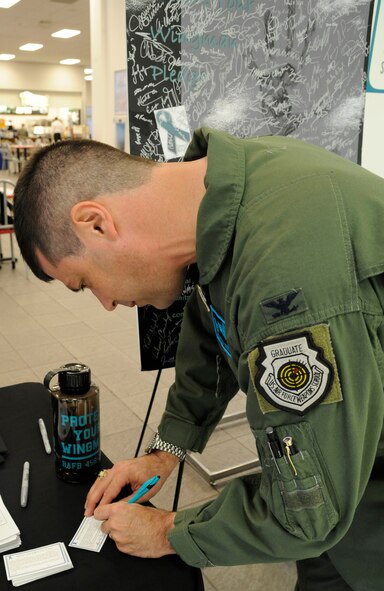 Col. Andrew Gebara, 2nd Bomb Wing commander, signs the Sexual Assault Prevention and Response pledge at the Exchange on Barksdale Air Force Base, La., April 23, 2013. April is Sexual Assault Awareness Month, and the goal is to raise public awareness about sexual violence, and to educate communities on how to prevent these actions. (U.S. Air Force photo/Airman 1st Class Andrew Moua)