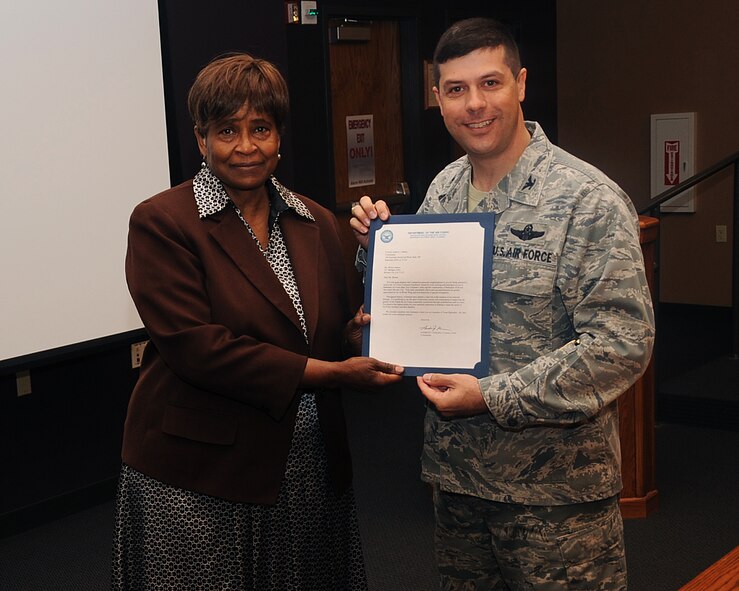 Shirley Barnes, Airman's Attic volunteer, receives a volunteer award from Col. Andrew Gebara, 2nd Bomb Wing commander, on Barksdale Air Force Base, La., April 24, 2013. She was recognized as an outstanding volunteer for the base and has volunteered more than 700 hours at the Airman's Attic and 200 hours at various other organizations. (U.S. Air Force photo/Senior Airman Sean Martin)