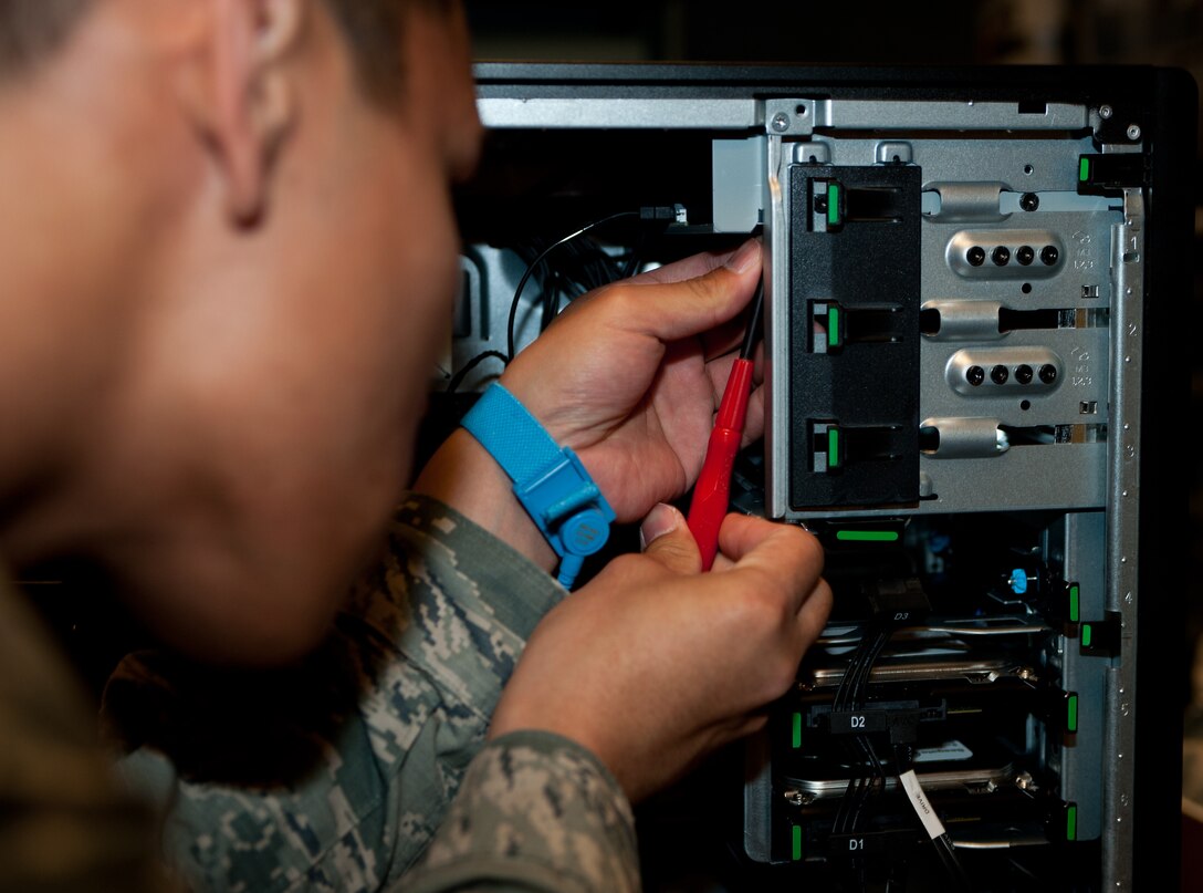 Senior Airman Luis Peralta, 28th Communications Squadron client systems technician, removes a hard drive from a computer at Ellsworth Air Force Base, S.D., April 17, 2013. Ellsworth saves an estimated $18,000 annually by having specialists repair existing computers instead of purchasing new machines. (U.S. Air Force photo by Airman 1st Class Alystria Maurer/Released)