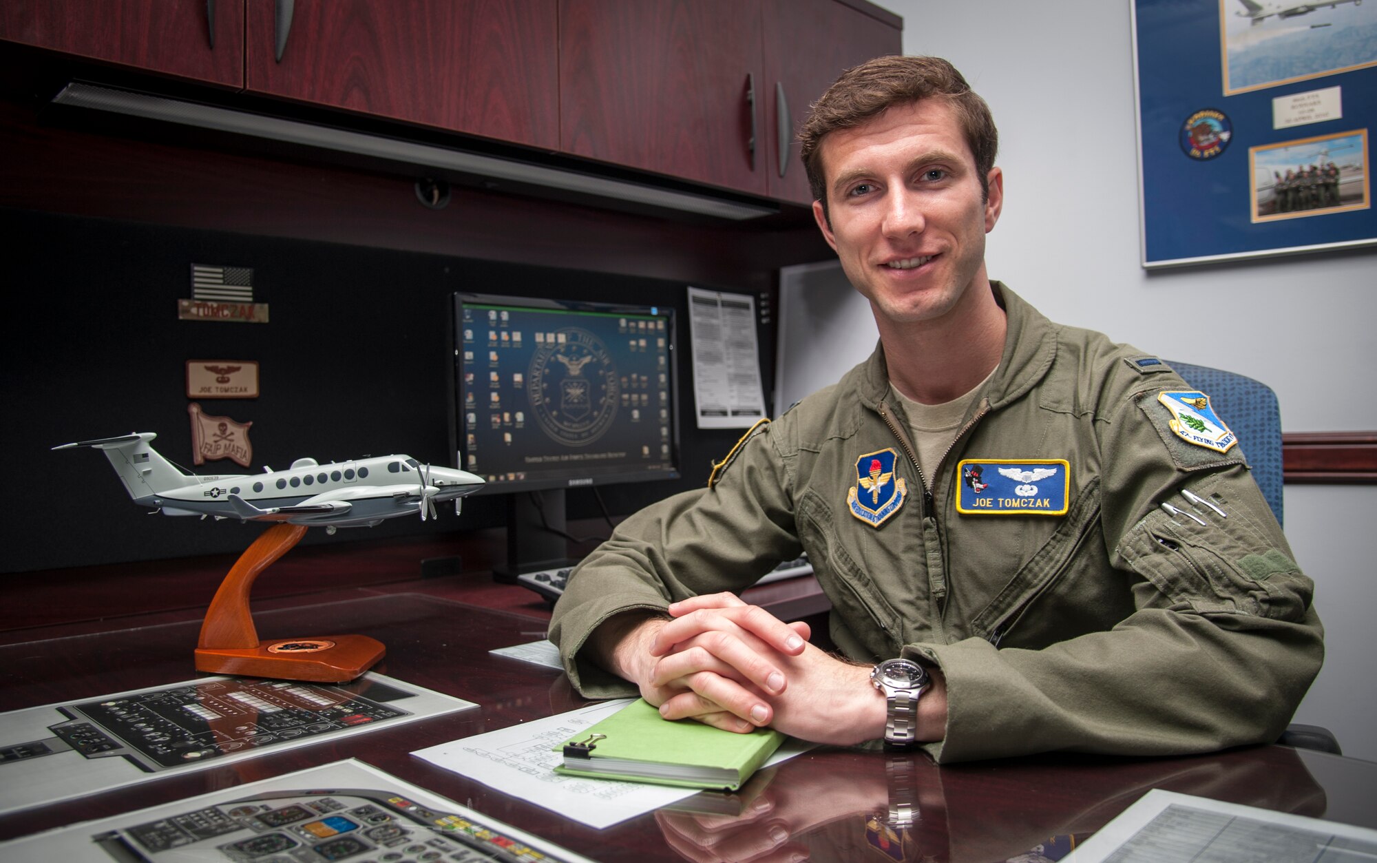 First Lt. Joseph Tomczak, 86th Flying Training Squadron instructor pilot, poses at his desk with a model of the MC-12W aircraft he flew in Afghanistan, at Laughlin Air Force Base, Texas, April 17, 2013. Tomczak was submitted for seven Air Medals and two achievement medals from his deployment to Bagram Air Field, Afghanistan, from June 2012 to Jan. 2013, where he served with the 4th Expeditionary Reconnaissance Squadron as a MC-12W mission pilot and assistant flight commander. (U.S. Air Force photo/Senior Airman Nathan Maysonet)