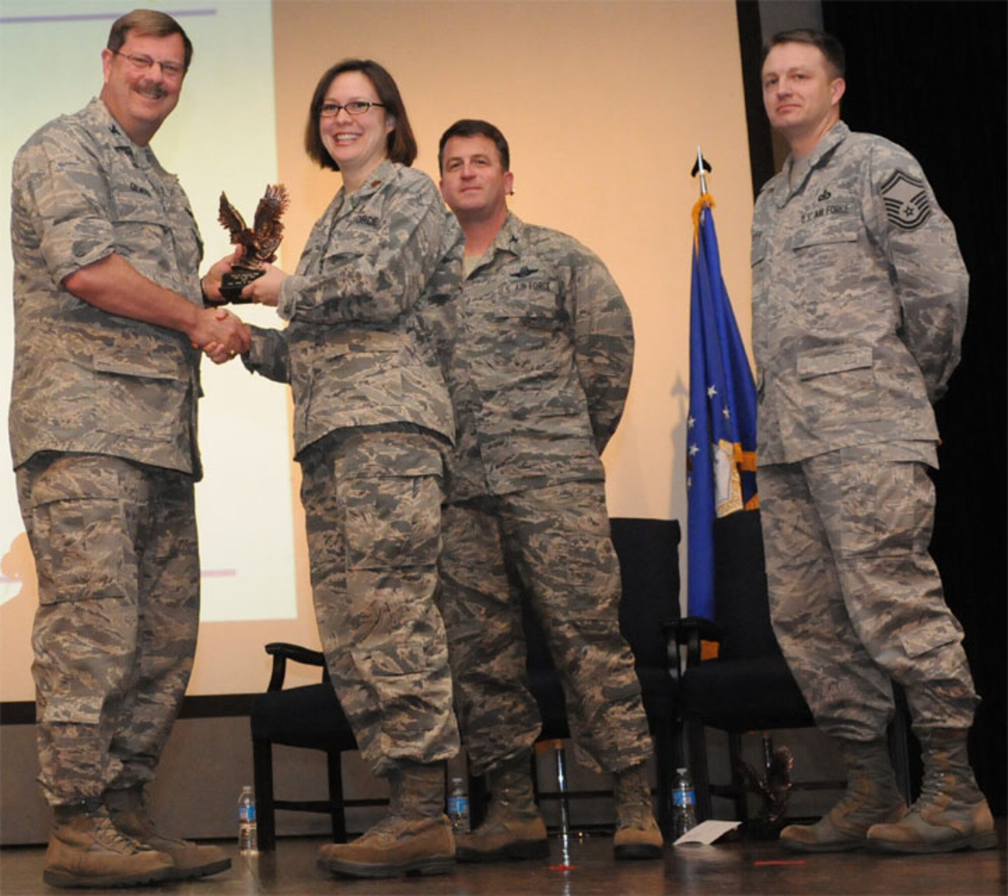 Col. Greg Gilmour, 916th Air Refueling Wing commander, awards Maj. Erin Pritchard the Company Grade Officer of the Year Award for 2012. Pritchard is a Reservist with teh 916th Force Support Squadron. (USAF photo by TSgt. Scotty Sweatt, 916ARW/PA)