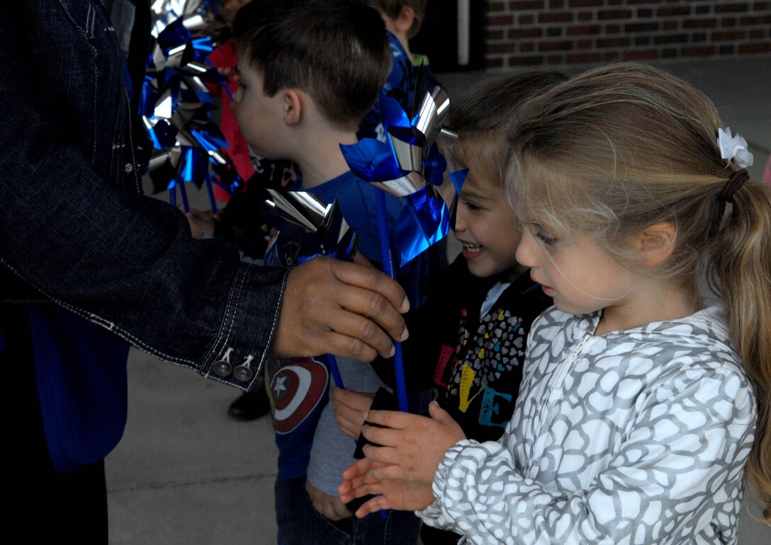 Antoinette Hyman, Langley Child Development Center supervisory child development technician, hands out pinwheels to her class April 13, 2013, at Langley Air Force Base, Va. The pinwheel and blue ribbon both represent Child Abuse Prevention month. (U.S. Air Force photo by Airman 1st Class Austin Harvill/Released)
