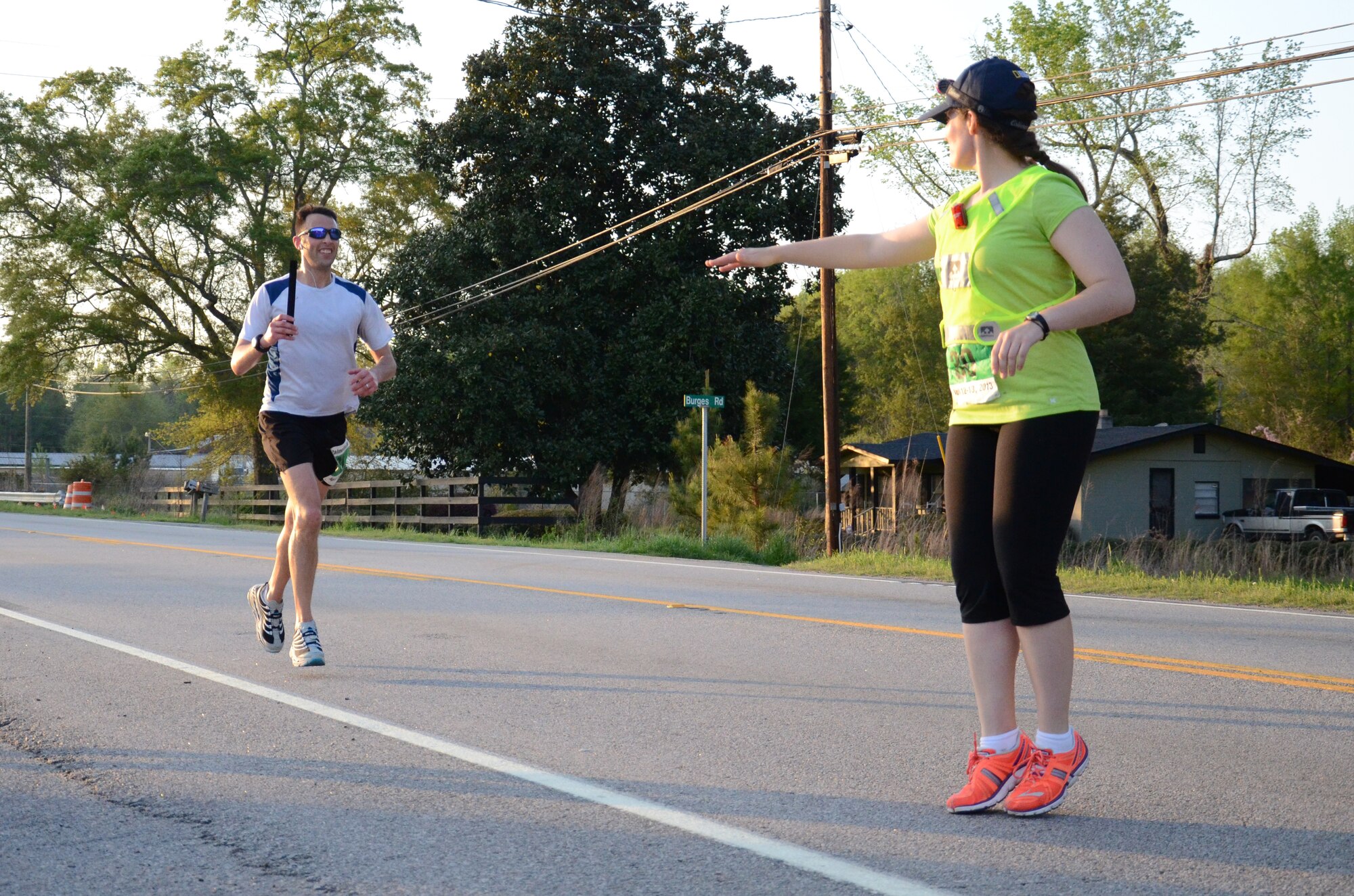 U.S. Air Force Airman 1st Class Molly Elder, 20th Fighter Wing Public Affairs broadcastor, stands ready to receive the baton from teammate U.S. Air Force Maj. Joshua Wennrich, 20th Equipment Maintenance Squadron commander, and begin another leg of the Palmetto 200 relay race, April 12, 2013, Santee, S.C. Both are members of the Road Warriors Running Club at Shaw Air Force Base, which took part in the overnight relay from Columbia, S.C., to Charleston, S.C., earning a time of 29:13:00 and ranking 25th overall. (U.S. Air Force photo by 2nd Lt. Earon E. Brown/Released)