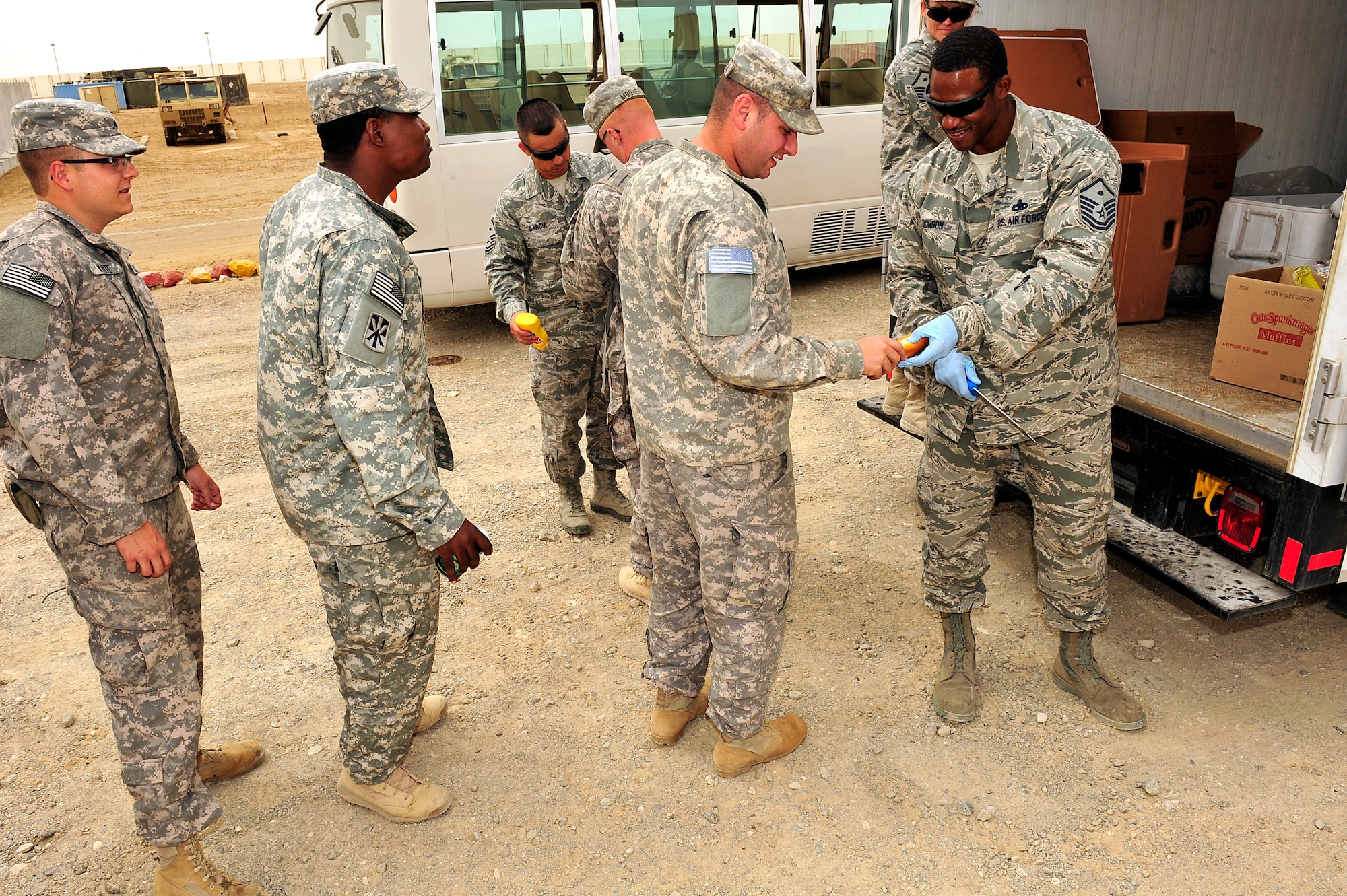 U.S. Air Force and Army first sergeants serve food to Soldiers and Airmen at an undisclosed location in Southwest Asia April 5, 2013.  The first sergeants prepared and served more than 300 hotdogs, cookies, snacks and drinks out of the ADAB First Sergeants Morale Wagon. The morale wagon is intended to help raise the morale of servicemembers, show them they care and give them an opportunity to talk and have a few minutes of fun with the first sergeants. (U.S. Air Force photo by Tech. Sgt. Christina M. Styer)