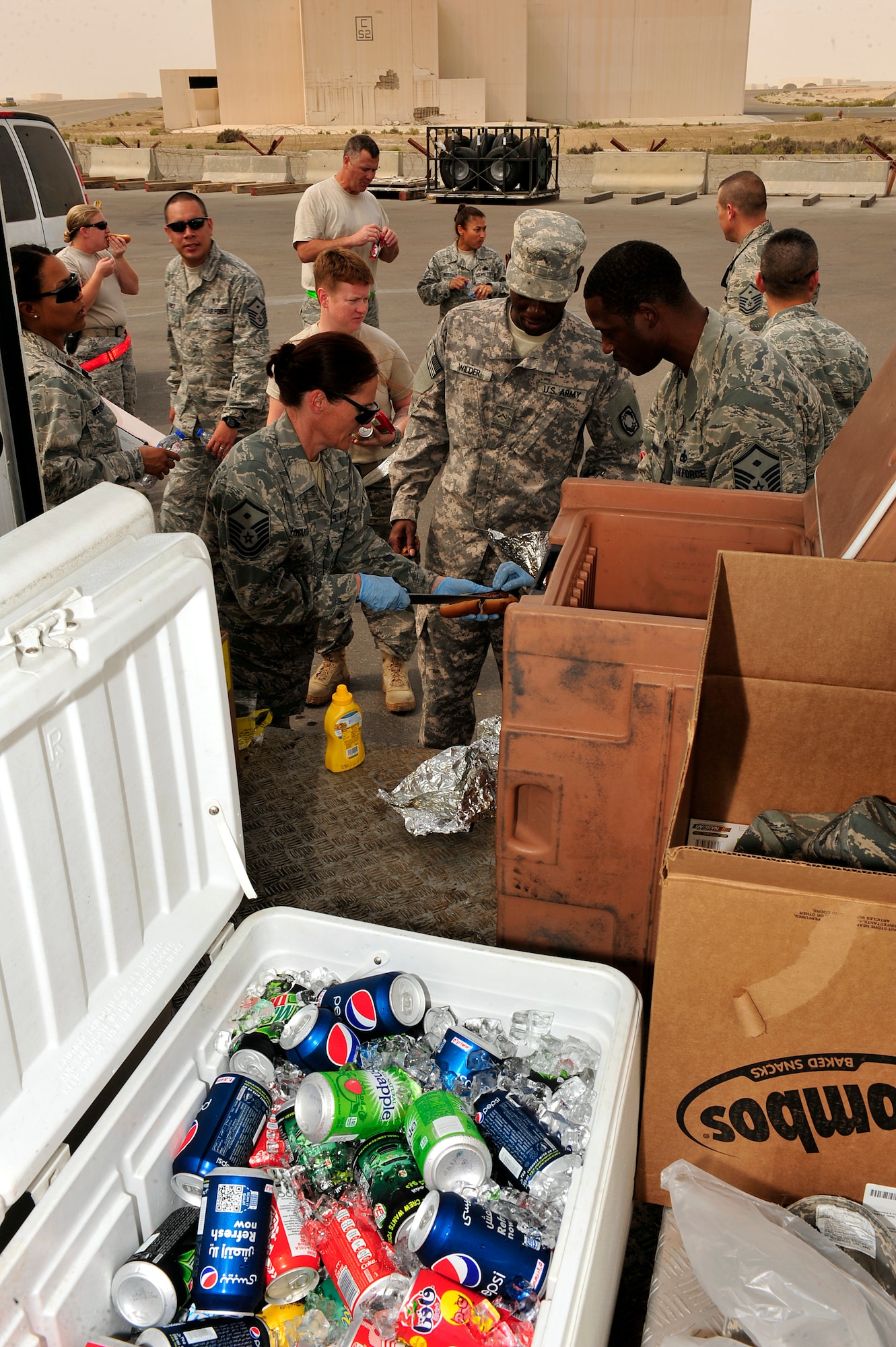 U.S. Air Force and Army first sergeants serve more than 300 hotdogs, cookies, snacks and drinks to Airmen and Soldiers at an undisclosed location in Southwest Asia April 5, 2013. The ADAB First Sergeants Morale Wagon is intended to help raise the morale of servicemembers, show them they care and give them an opportunity to talk and have a few minutes of fun with the first sergeants. (U.S. Air Force photo by Tech. Sgt. Christina M. Styer)