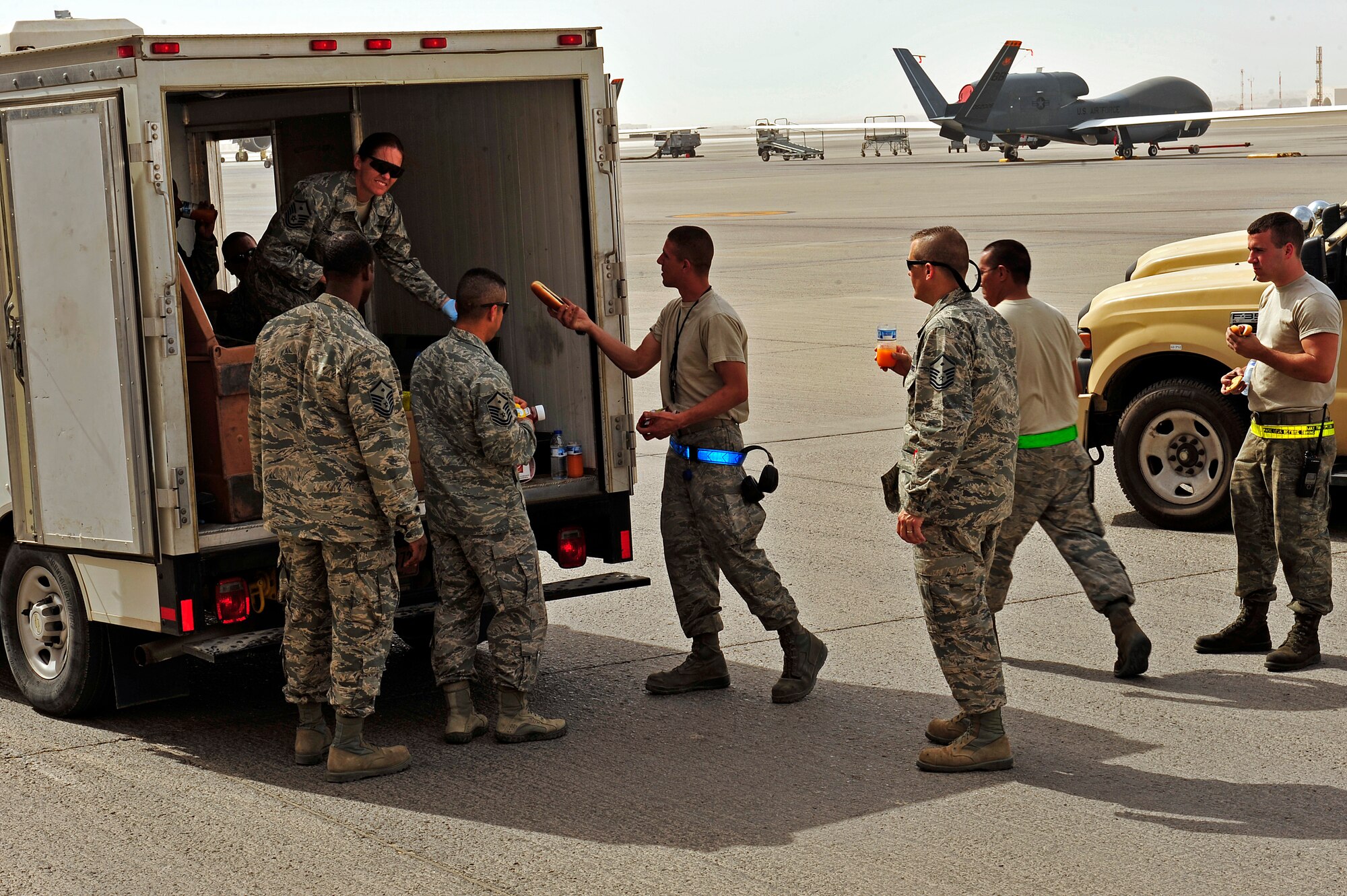 U.S. Air Force and Army first sergeants serve Airmen on the flightline at the ADAB First Sergeant's Morale Wagon at an undisclosed location in Southwest Asia April 5, 2013. The first sergeants prepared and served more than 300 hotdogs, cookies, snacks and drinks to Airmen and Soldiers. The morale wagon is intended to help raise the morale of servicemembers, show them they care and give them an opportunity to talk and have a few minutes of fun with the first sergeants. (U.S. Air Force photo by Tech. Sgt. Christina M. Styer)