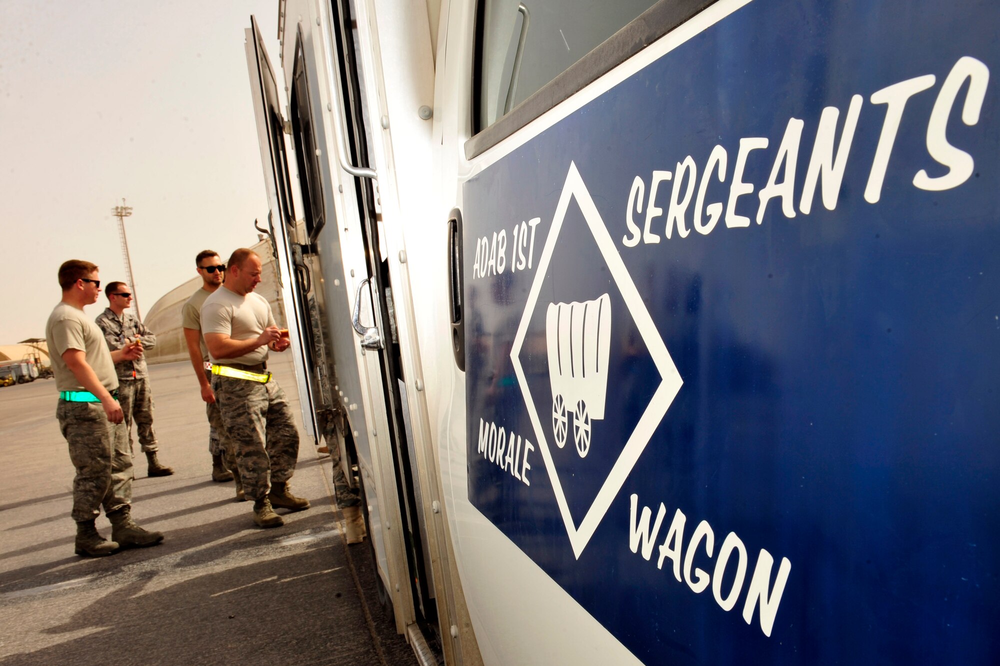 U.S. Air Force and Army First Sergeants assigned to the 380th Air Expeditionary Wing and Headquarters and Headquarters Battery 1-62 Air Defense Artillery serve hotdogs, cookies, snacks and drinks to servicemembers on the flightline during the monthly ADAB First Sergeants Morale Wagon at an undisclosed location in Southwest Asia April 5, 2013. The first sergeants use the morale wagon as an additional way to get out amongst Airmen and Soldiers, talk with them and raise their morale. (U.S. Air Force photo by Tech. Sgt. Christina M. Styer)
