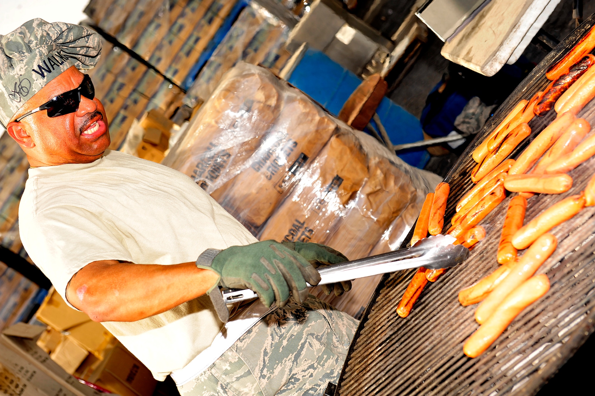 U.S. Air Force Master Sgt. Kevin Walker, 380th Expeditionary Aircraft Maintenance Squadron first sergeant, deployed from Elmendorf Air Force Base, Alaska, grills more than 300 hotdogs for the ADAB First Sergeant's Morale Wagon at an undisclosed location in Southwest Asia April 5, 2013. Once a month the first sergeants serve hotdogs, cookies, snacks and drinks to Airmen and Soldiers around base and on the flightline in order to help raise the morale of servicemembers. "The morale wagon is important because it shows we care," Walker explained, "we come to them so they know we're here if they ever need anything." (U.S. Air Force photo by Tech. Sgt. Christina M. Styer)