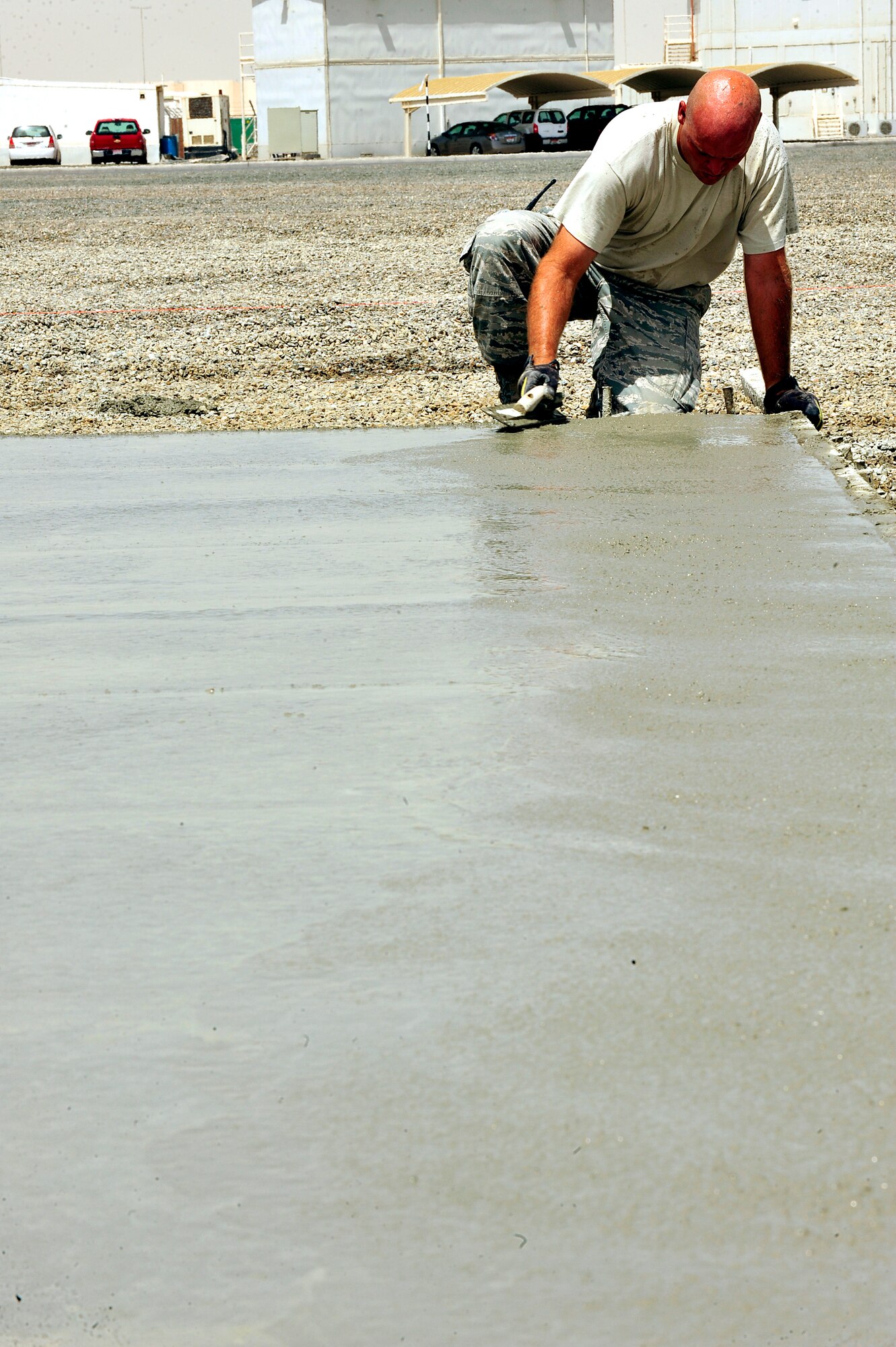U.S. Air Force Tech. Sgt. Paul Laird, 380th Air Expeditionary Wing pavement and construction equipment craftsman, edges a new concrete pad at an undisclosed location in Southwest Asia April 16, 2013. In order to aid the transition to a more enduring base, the Dirt Boyz have dug trenches, poured concrete, set up t-walls, and concrete pads throughout the installation. Laird is deployed from Charleston Air Force Base, S.C. (U.S. Air Force photo by Tech. Sgt. Christina M. Styer)