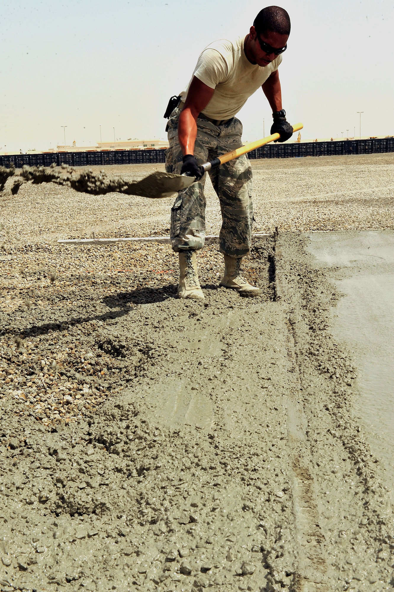 U.S. Air Force Staff Sgt. Duncan Bolt, 380th Air Expeditionary Wing structures journeyman, removes excess concrete along freshly poured pads at an undisclosed location in Southwest Asia April 16, 2013. There are 20 "Dirt Boyz" responsible for constructing projects that will transition the 380th Air Expeditionary Wing from expeditionary to enduring. Bolt is deployed from Hurlburt Field, Fla. (U.S. Air Force photo by Tech. Sgt. Christina M. Styer)