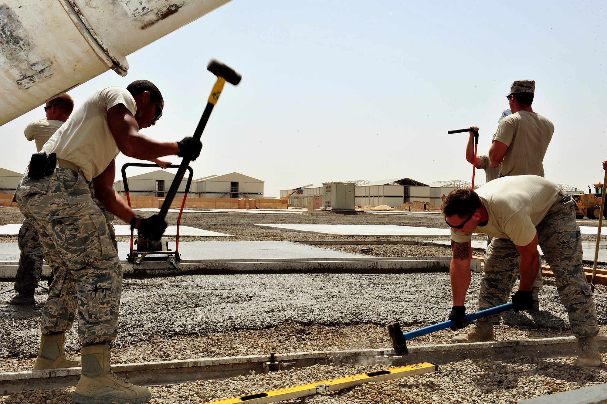 U.S. Air Force Staff Sgts. Duncan Bolt and Garrett Hanson, 380th Air Expeditionary Wing structures journeymen, pound stakes into a frame used for laying concrete pads at an undisclosed location in Southwest Asia April 16, 2013. The "Dirt Boyz" have dug trenches, poured concrete, set up t-walls, and concrete pads throughout the installation to aid in the transition from expeditionary to enduring. Bolt is deployed from Hurlburt Field, Fla., and Hanson is deployed from Mountain Home Air Force Base, Idaho. (U.S. Air Force photo by Tech. Sgt. Christina M. Styer)