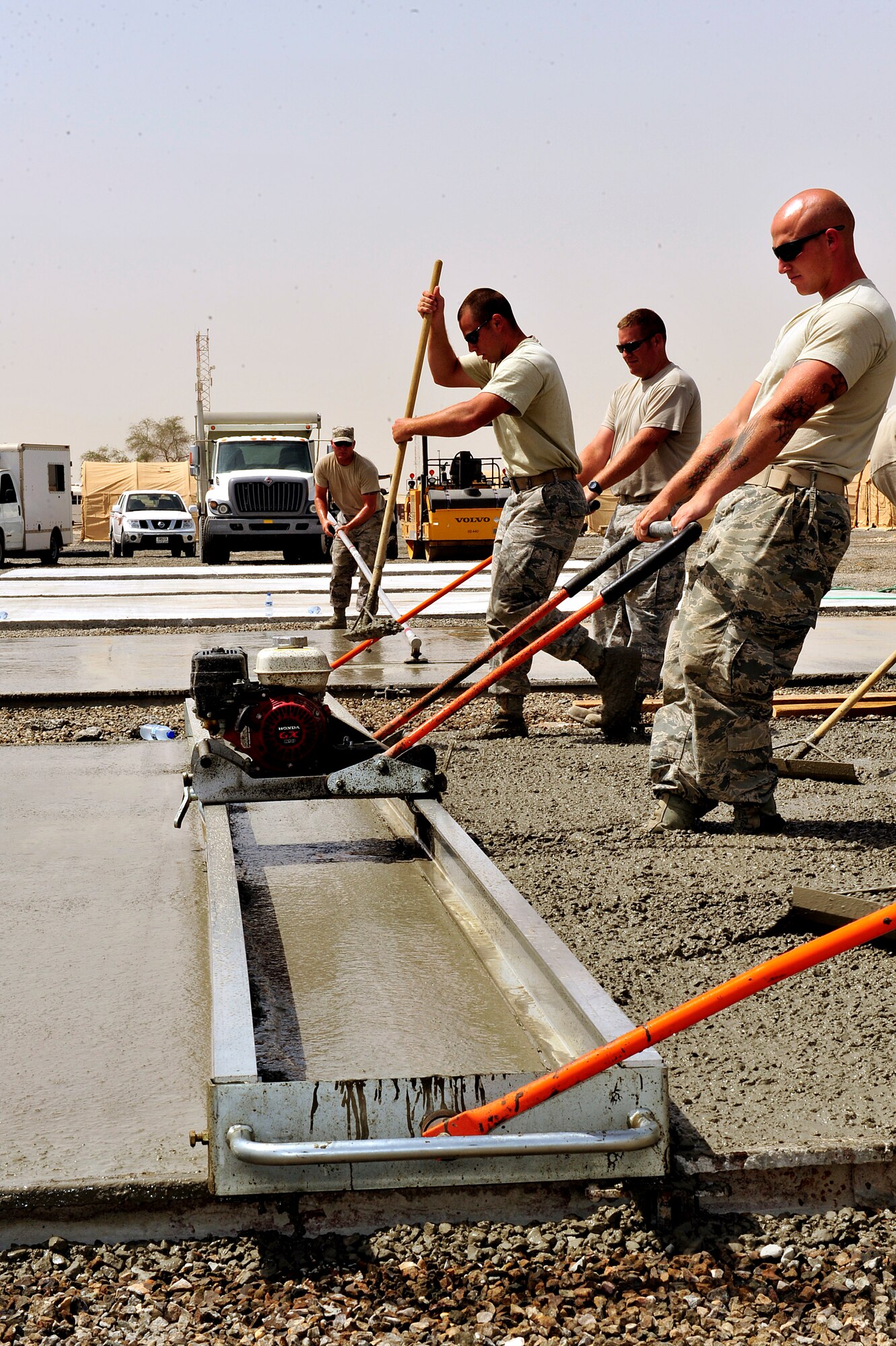 U.S. Air Force Airmen assigned to the 380th Expeditionary Civil Engineer Squadron known as "Dirt Boyz" lay concrete pads at an undisclosed location in Southwest Asia April 16, 2013. There are 20 "Dirt Boyz" responsible for constructing projects that will transition the base from expeditionary to enduring. (U.S. Air Force photo by Tech. Sgt. Christina M. Styer)