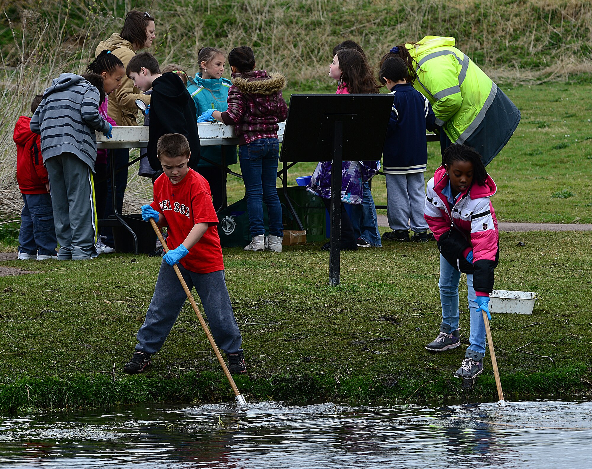 ROYAL AIR FORCE LAKENHEATH, England— Ryan Michaud, son of Maj. Derrick Michaud, 95th Reconnaissance Squadron, RAF Mildenhall, and Aleya McCoy (right), daughter of Staff Sgt. Jakeith Robinson, 48th Force Support Squadron, gather algae from Defenders Park during a pond dipping activity for Earth Week April 18, 2013. Earth Day is an annual event held worldwide to show support for environmental protection. (U.S. Air Force photo by Staff Sgt. Stephanie Mancha)