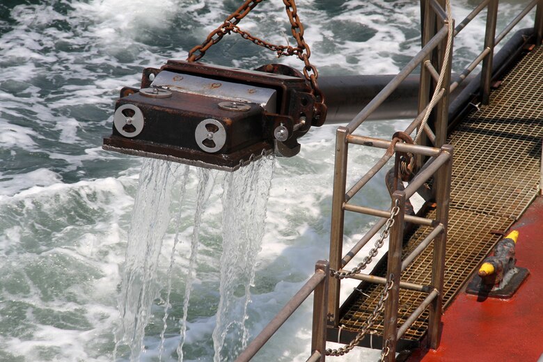 SUFFOLK, Va. – The Currituck's captain, Martin Willis, prepares to drop one drag arm into Bennett’s Creek to start dredging April 23, 2013. Operating much like a giant vacuum cleaner, the vessel's drag arms hang from each side and are lowered into the channel. Each drag arms sucks a water and sand mixture, known as slurry, from the channel bottom. The slurry then passes through the drag heads and pipelines into the hopper. The U.S. Army Corps of Engineers' dredge Currituck arrived at Bennett’s Creek April 20, 2013 to remove approximately 4,000 cubic yards of sand to increase the channel depth from 2 feet to 6 feet.