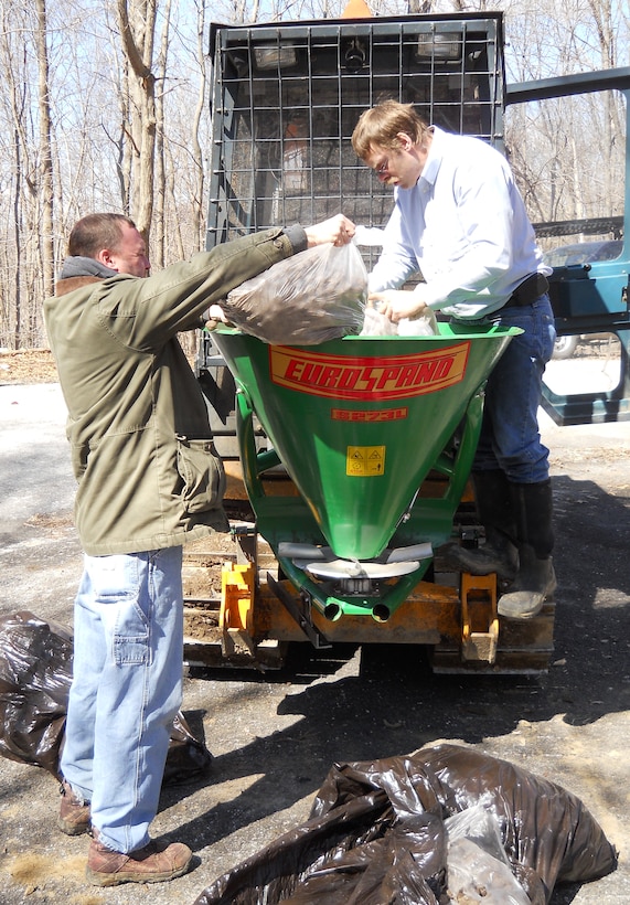 Carl Johnson (left) from Aberdeen Test Center and Tim Cary from the US Army Corps of Engineers Cold Regions Research Laboratory load the first grass seed balls into the spreader for distribution on Cranberry Mountain, an ordnance impact area used by the U.S. Military Academy at West Point, N.Y. Because of the risks involved due to unexploded ordnance in the area, U.S. Army Engineering and Support Center, Huntsville’s  Ordnance and Explosives Design Center was called in to contract the use of radio-controlled agricultural equipment which had already been used on other Army installations ranges.  