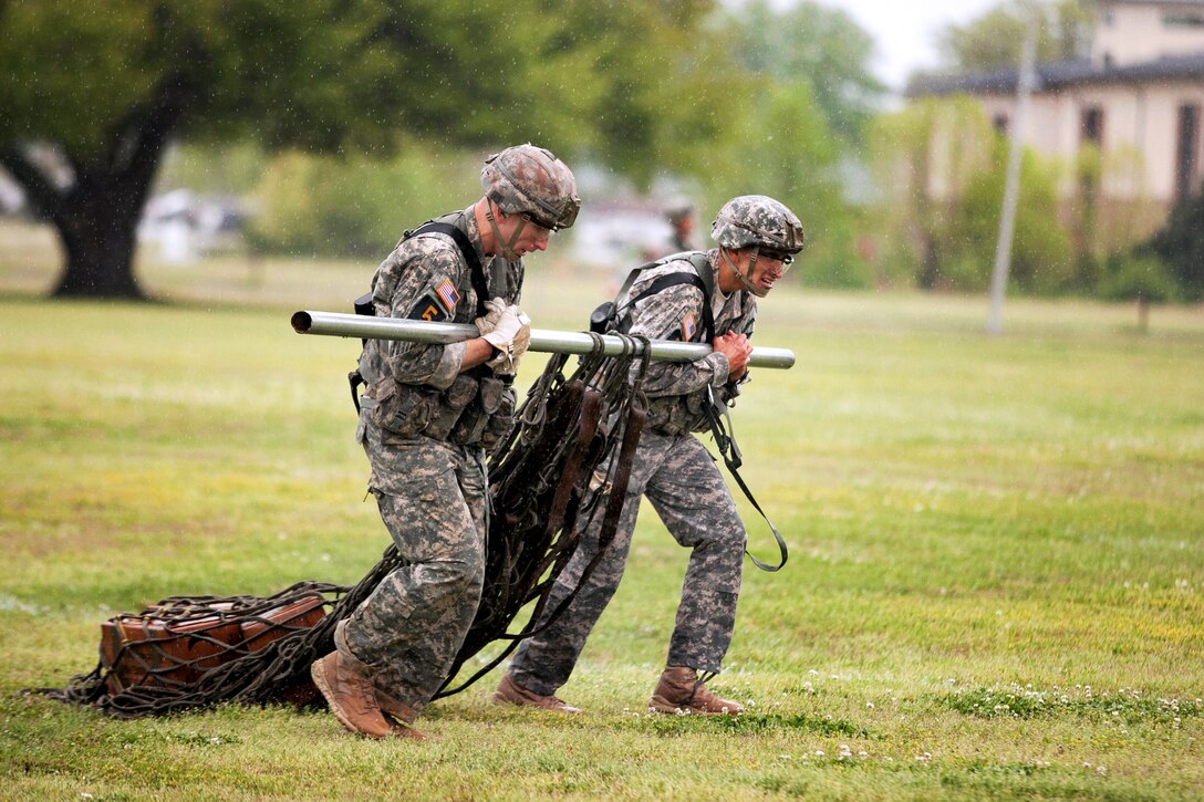 Army Staff Sgts. Joshua Rolfes, left, and Anthony Vasquez, right, pull a sling load recovery after a fast rope insertion-extraction system dropped them off from a UH-60 Black Hawk helicopter during the final day of the 30th annual Best Ranger Competition on Fort Benning, Ga., April 14, 2013. Rolfes and Vasquez are assigned to the 4th Infantry Division.