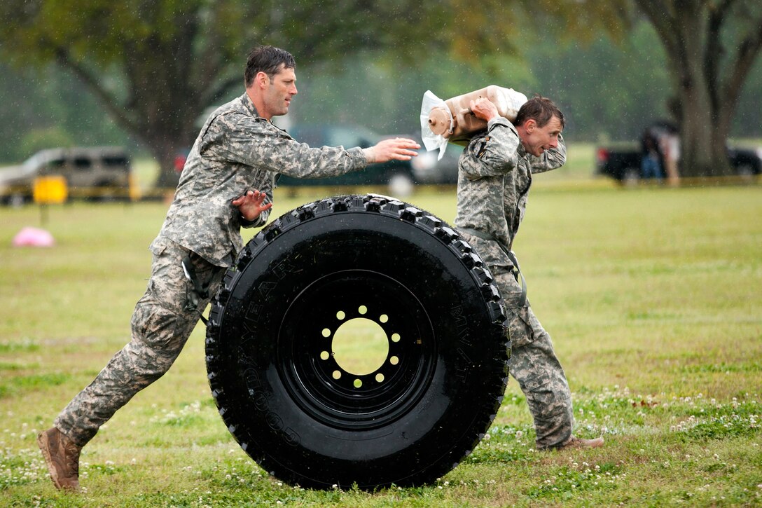 Army Master Sgt. Christopher Nelms and Sgt. Maj. Walter Zajkowski compete against each other in the sling load recovery event during the final day of the 30th annual Best Ranger Competition on Fort Benning, Ga., April 14, 2013. Nelms and Zajkowski are assigned to Headquarters Company, U.S. Army Special Operations Command.