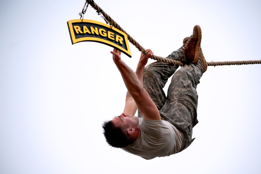 A soldier touches the Ranger tab after completing the rope crawl portion of the water confidence obstacle during the final day of the 30th annual Best Ranger Competition on Fort Benning, Ga., April 14, 2013.