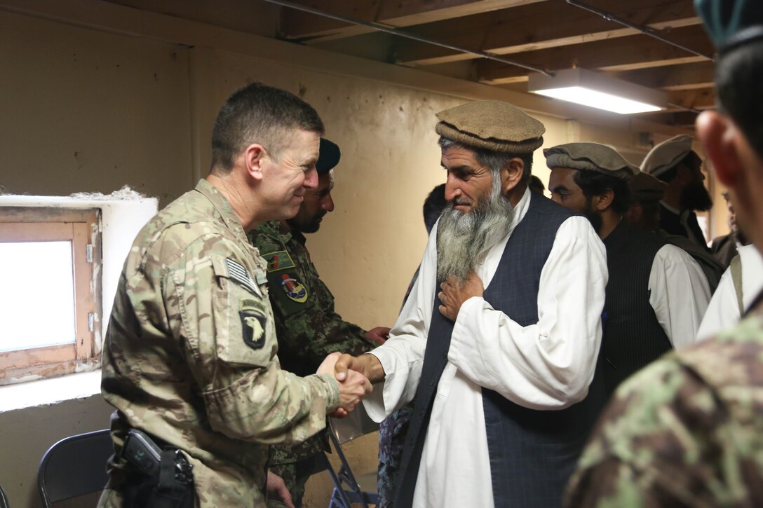 U.S. Army Col. J.P. McGee, left, speaks with Haji Mosolen, chief of the shura, during a meeting on Forward Operating Base Bostic, Kunar province, Afghanistan, April 20, 2013. McGee is commander, 101st Airborne Division's 1st Brigade Combat Team.
