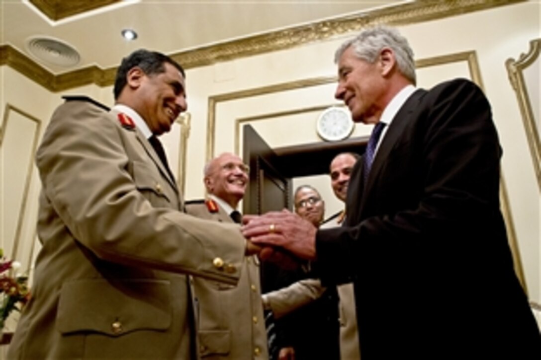 U.S. Defense Secretary Chuck Hagel, right, shakes hands with Egyptian Maj. Gen. Abd Al Halim Fouad as Maj. Gen. Mohamed Said al-Assar looks on in Cairo, April 24, 2013. Egypt is Hagel's fourth stop on a six-day trip to the Middle East to meet with defense counterparts.