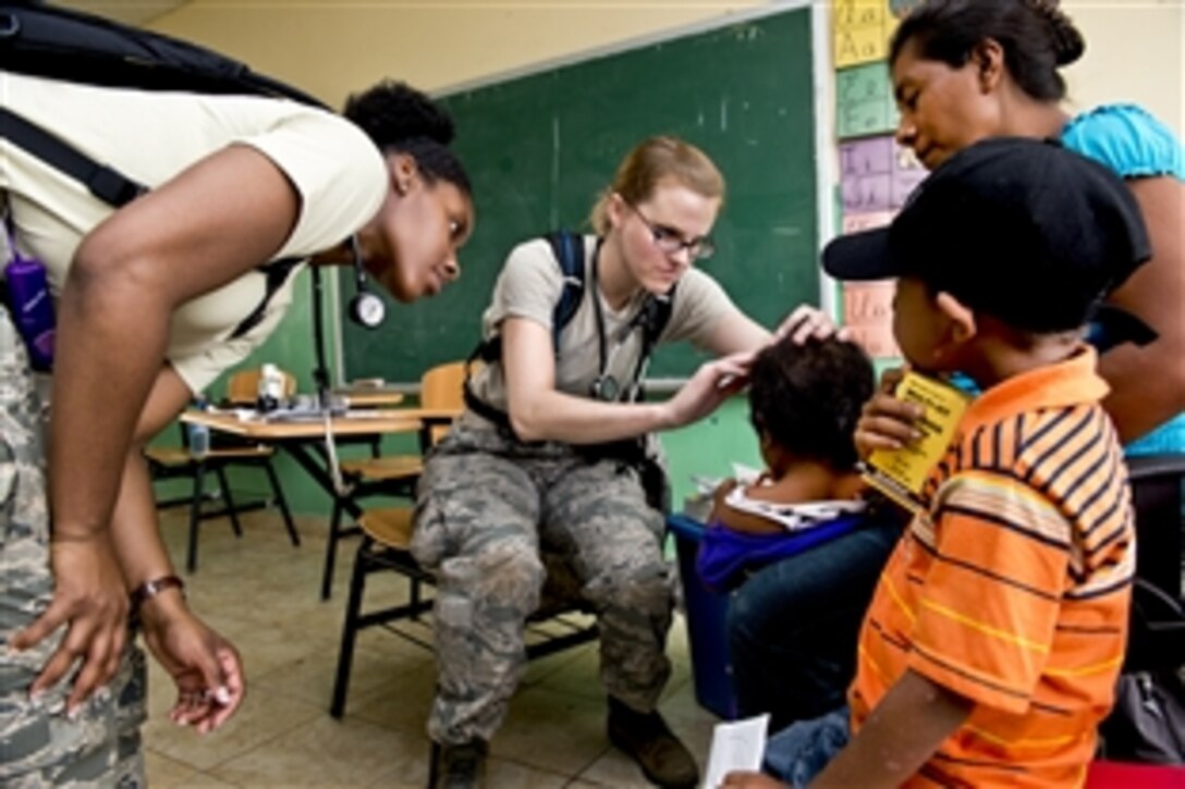 U.S. Air Force Capts. Rebecca Slogic, center, and Chauncey Tarrant examine a child during medical readiness training as part of Beyond the Horizon 2013 in Cerro Plata, Panama, April 15, 2013. Slogic and Tarrant are pediatricians assigned to the San Antonio Military Medical Center in Texas.