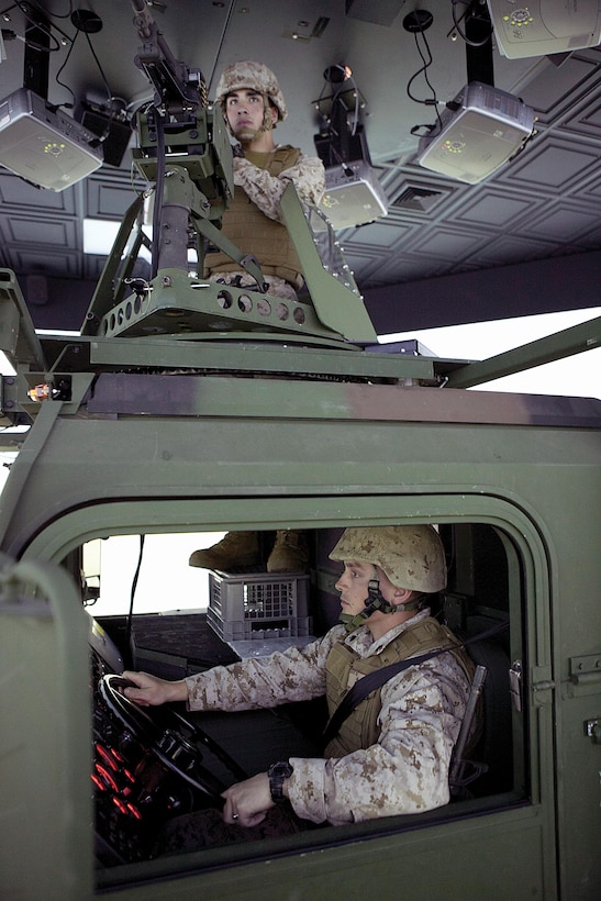 Cpl. William R. Love, driver, and Pfc. Zagros Dawoudi, turret gunner, train in a 7-ton truck simulator at the combat convoy simulator April 23 at Camp Hansen. Civilian contractors who operate the simulator and others like it attended the combat camera training device expo to inform service members about the training opportunities available to them. The simulator provides Marines with a variety of combat scenarios where they can train in a safe environment. Love is a data network specialist, and Dawoudi is a motor vehicle transport operator. Both are with Combat Logistics Regiment 35, 3rd Marine Logistics Group, III Marine Expeditionary Force. Photo by Lance Cpl. Anne K. Henry
