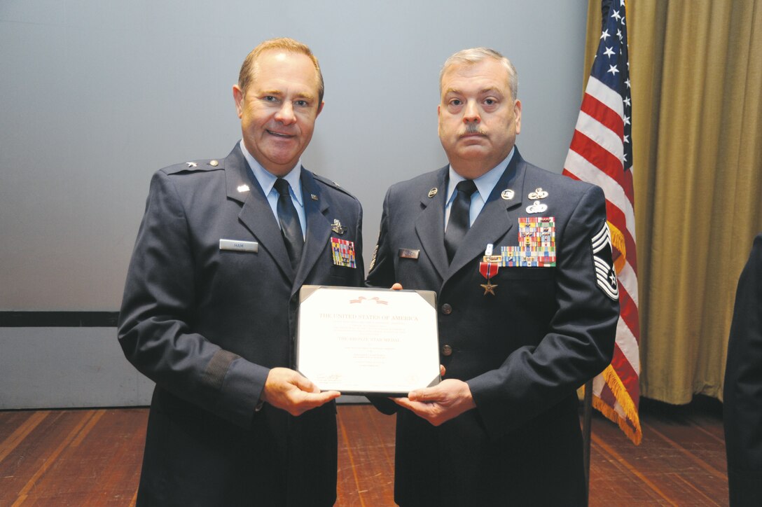 Air Force Brig. Gen. Norman Ham, commander of the 440th Airlift Wing, presents the Bronze Star Medal to Chief Master Sgt. Donald V. Roberts, superintendent, 996th Air Expeditionary Squadron, Feb. 9, for his actions while deployed to Afghanistan. Roberts currently serves as a logistics manager with Marine Corps Logistics Command as a Civilian-Marine.