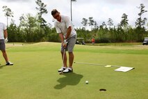 Cpl. Matthew Lemaitre, Marine Aviation Logistics Squadron 29 precision measurement equipment technician, putts his golf ball into hole four at Bear Trails Golf Course in Jacksonville, N.C. during the Marine Corps Air Station New River Marine Corps Community Services Spring Golf Tournament, April 19.
